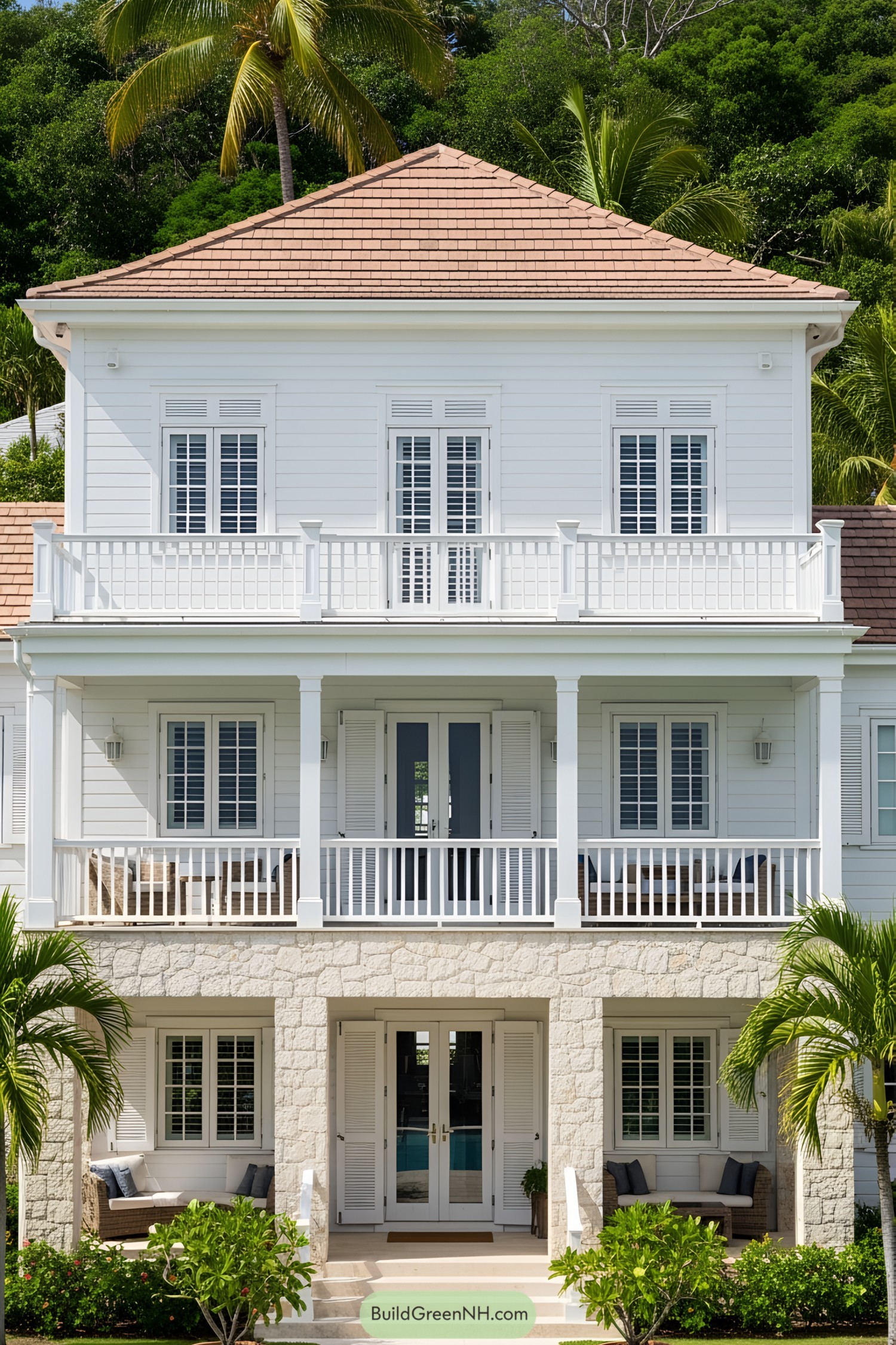 White Caribbean house with a wooden balcony and lush greenery