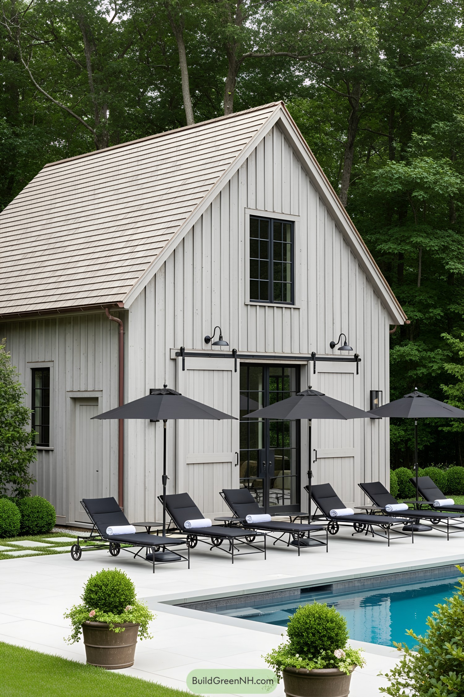 Farmhouse poolside with lounge chairs and umbrellas