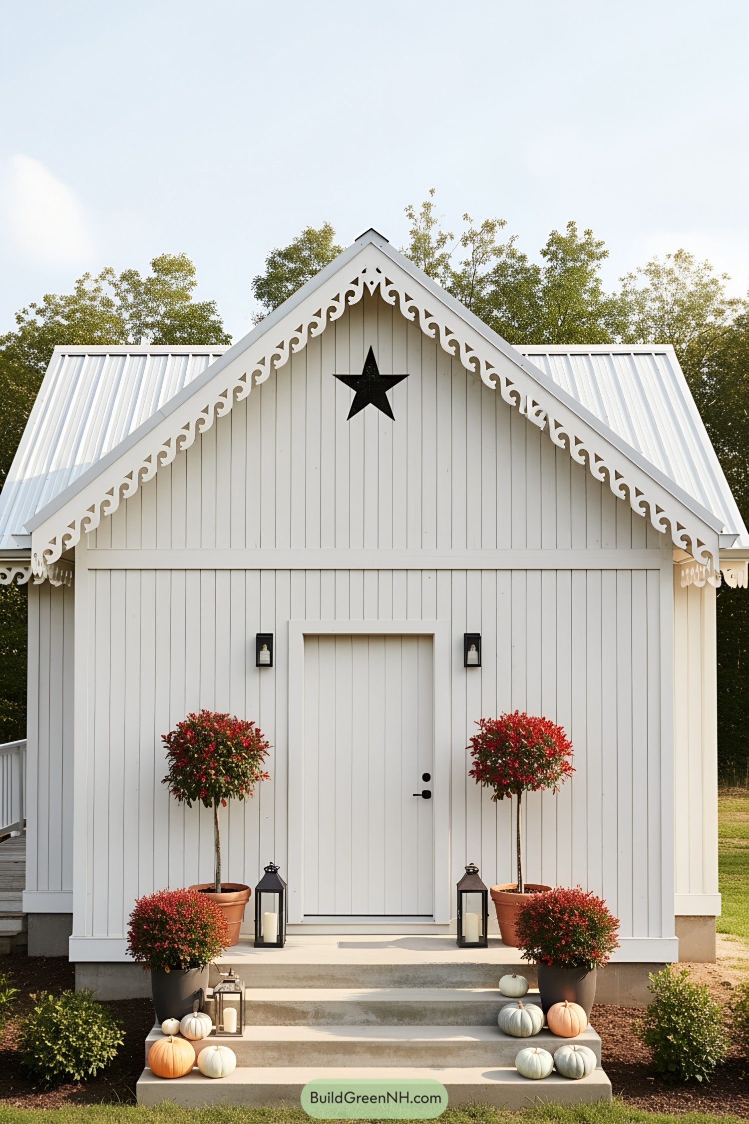 White cottage with star, trees, and pumpkins