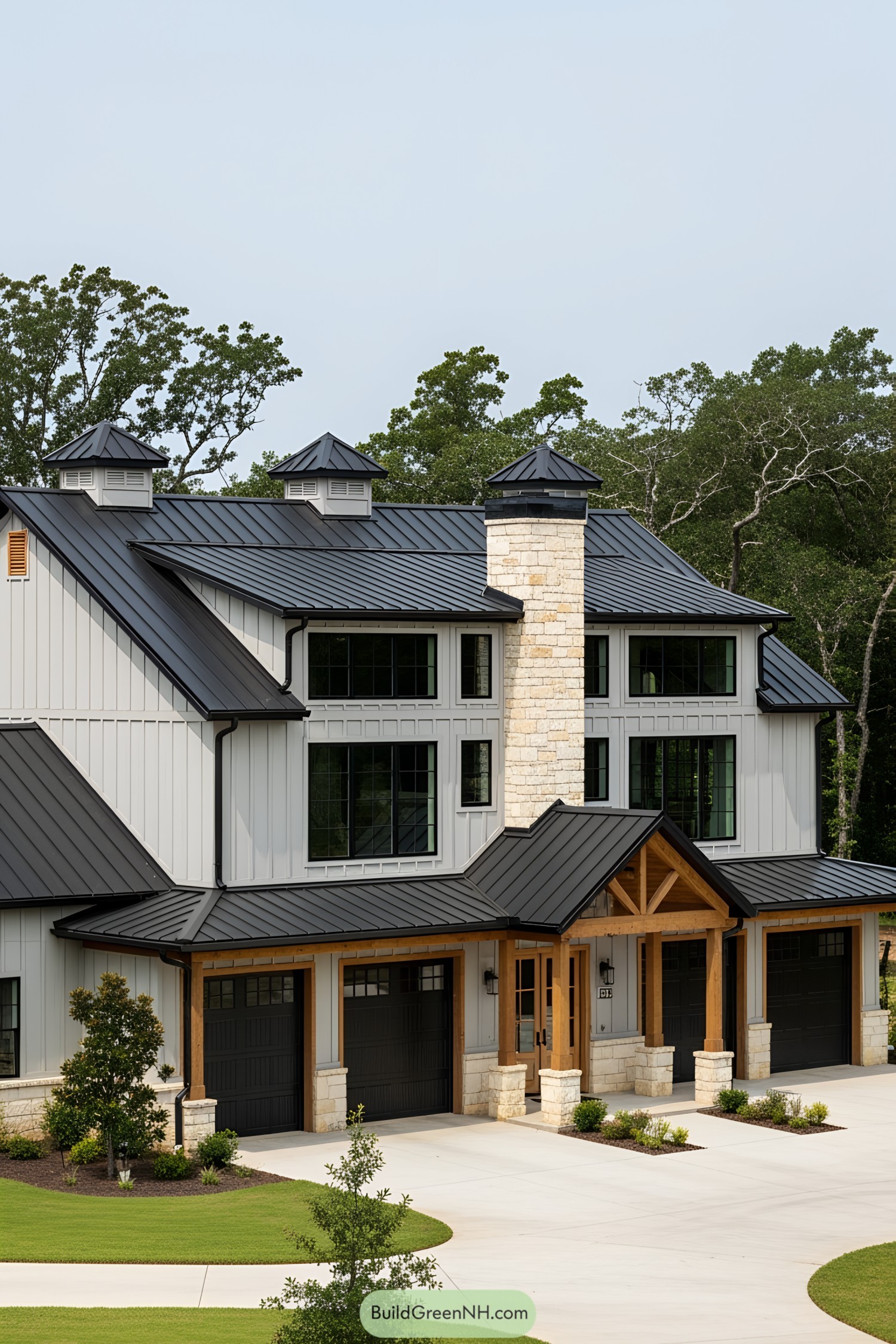 Stylish barndominium with black roofing and stone features