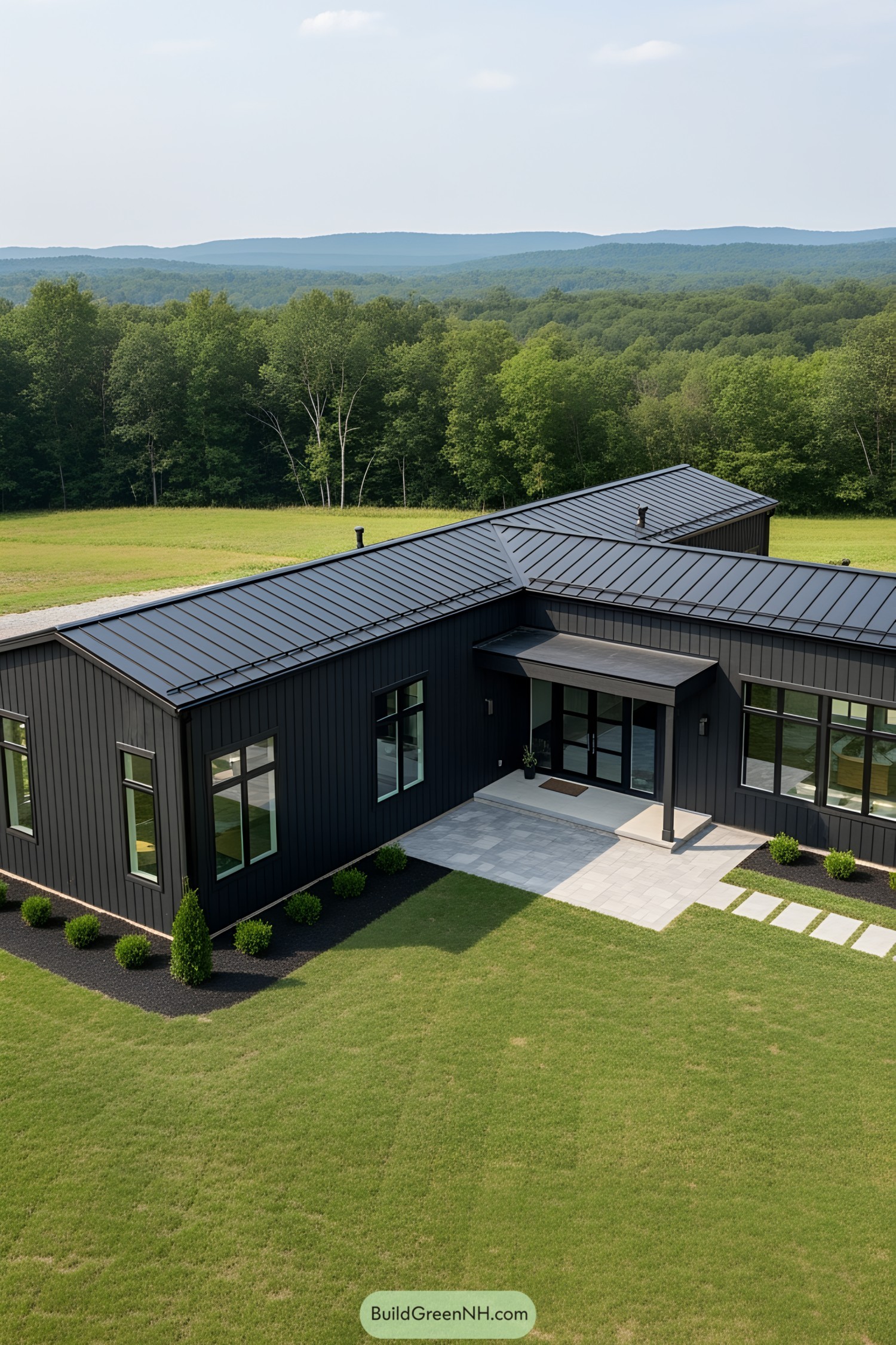 Modern L-shaped house with sleek black exterior surrounded by lush greenery