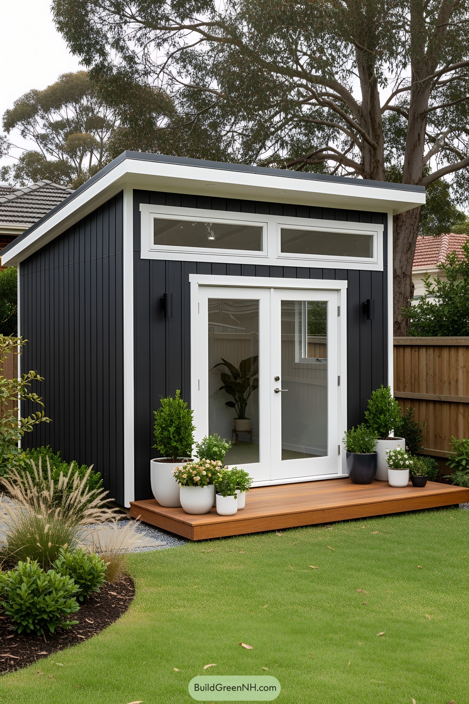 Compact black shed with white trim and a small wooden deck