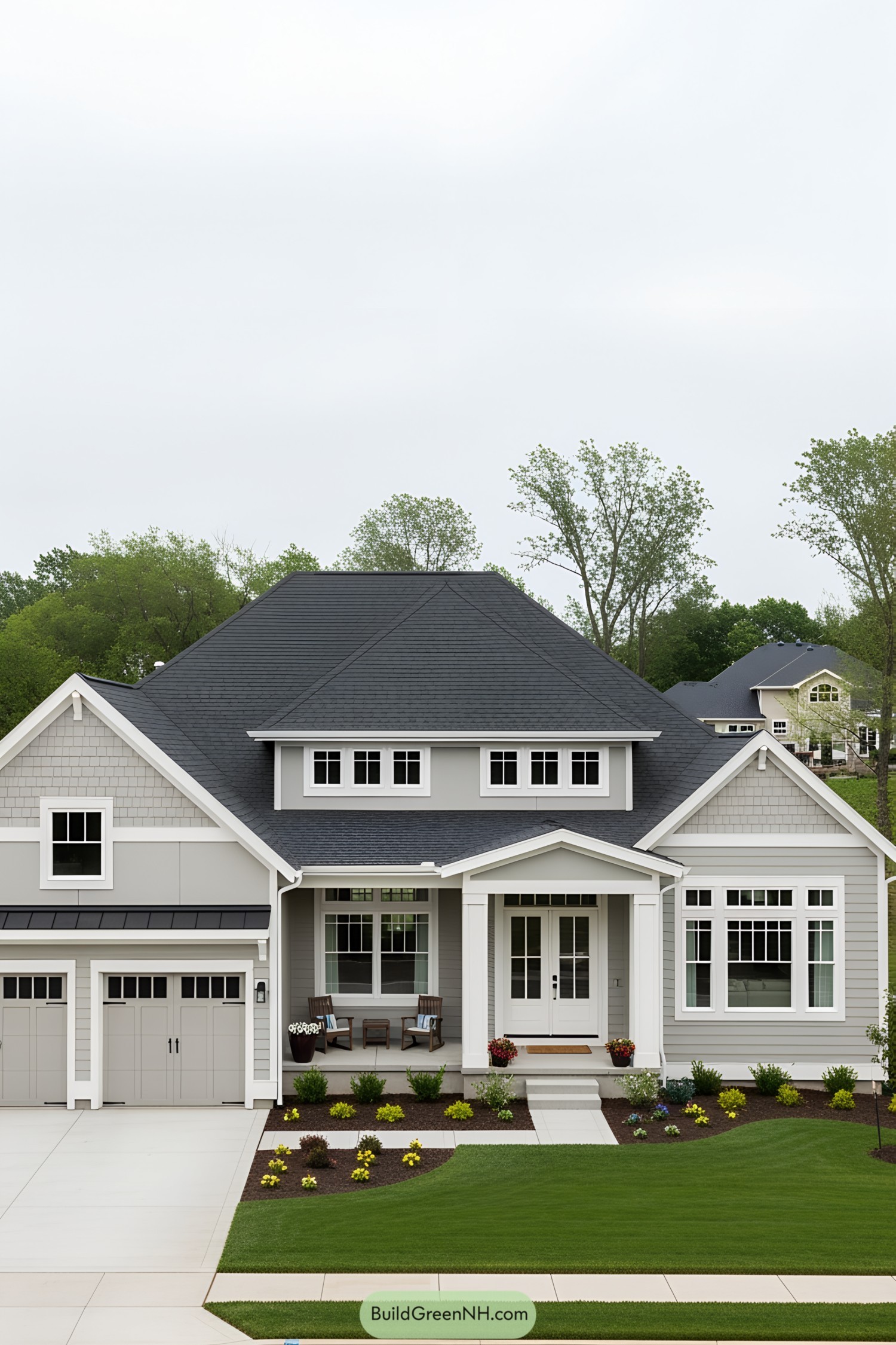 Classic home with gray siding and black roof, surrounded by lush greenery