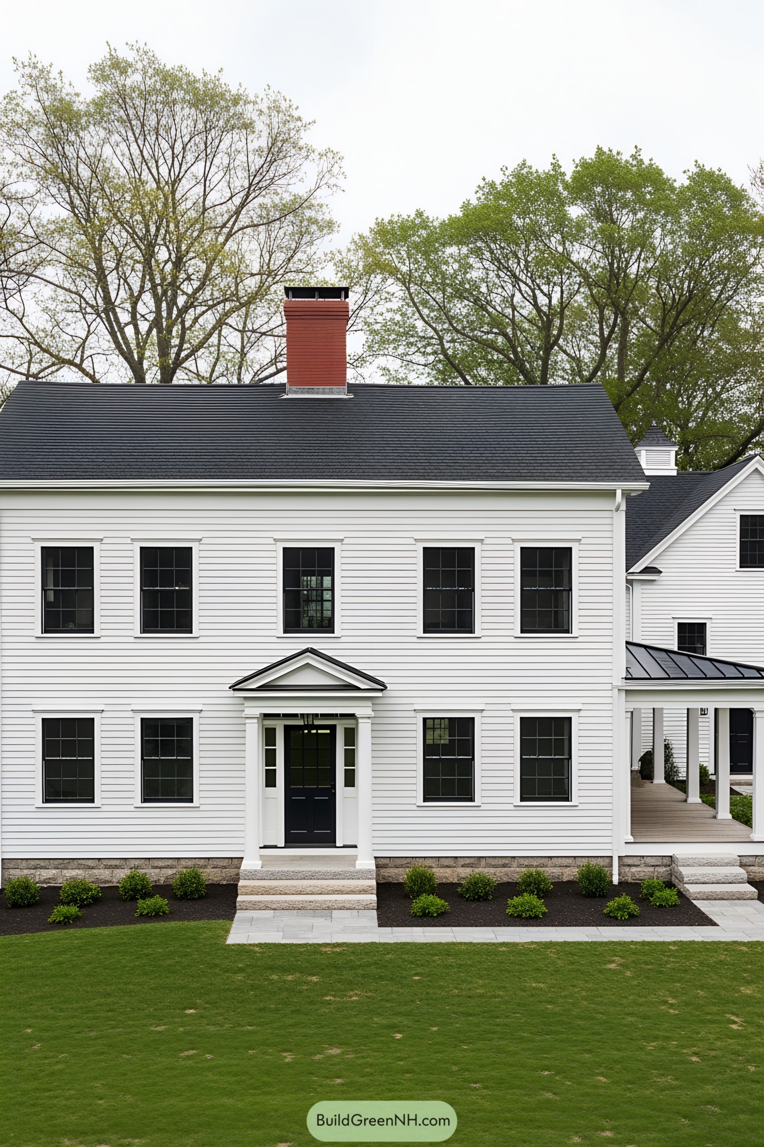 White farmhouse with black windows and red chimney