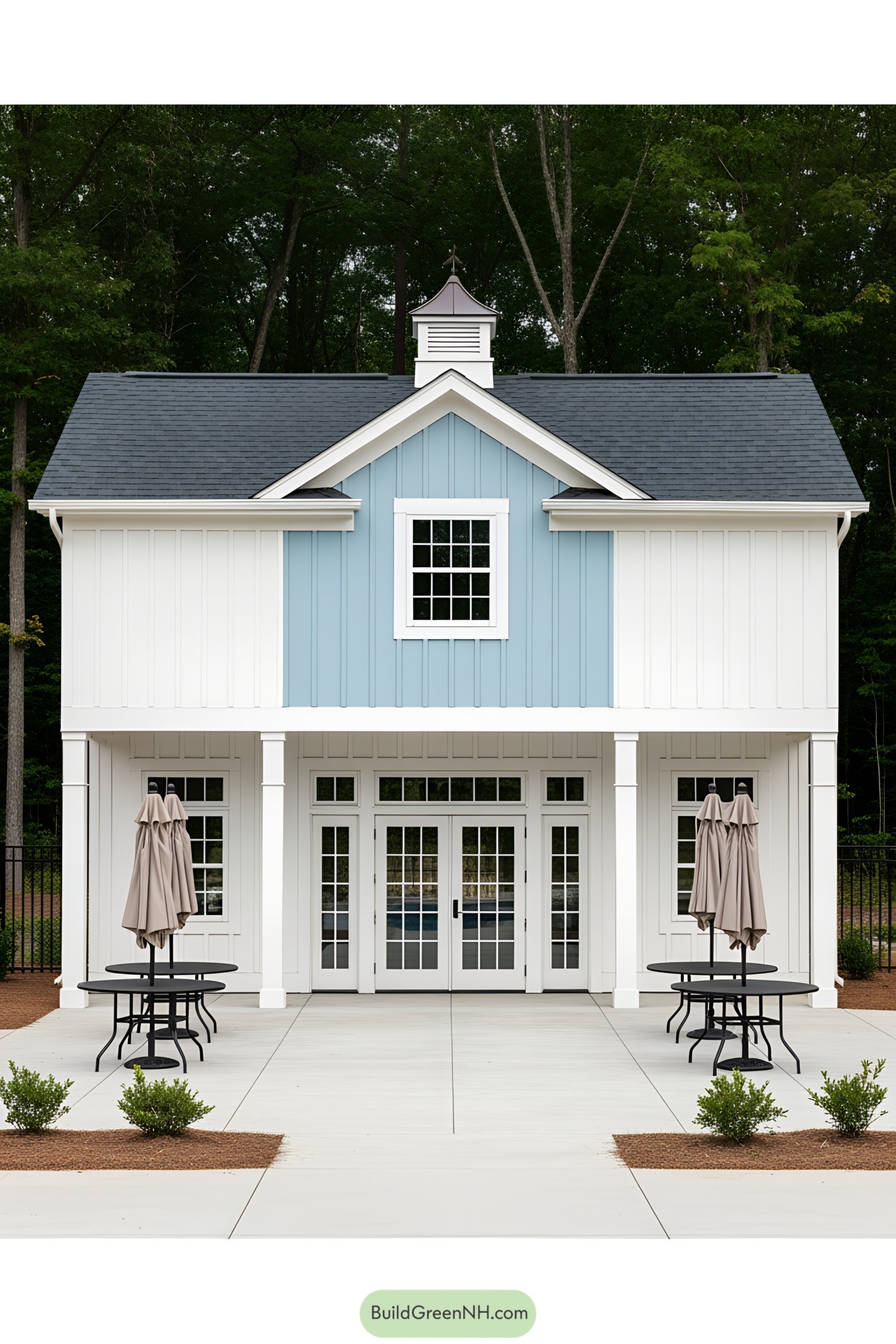 White and blue pool house with patio tables and umbrellas