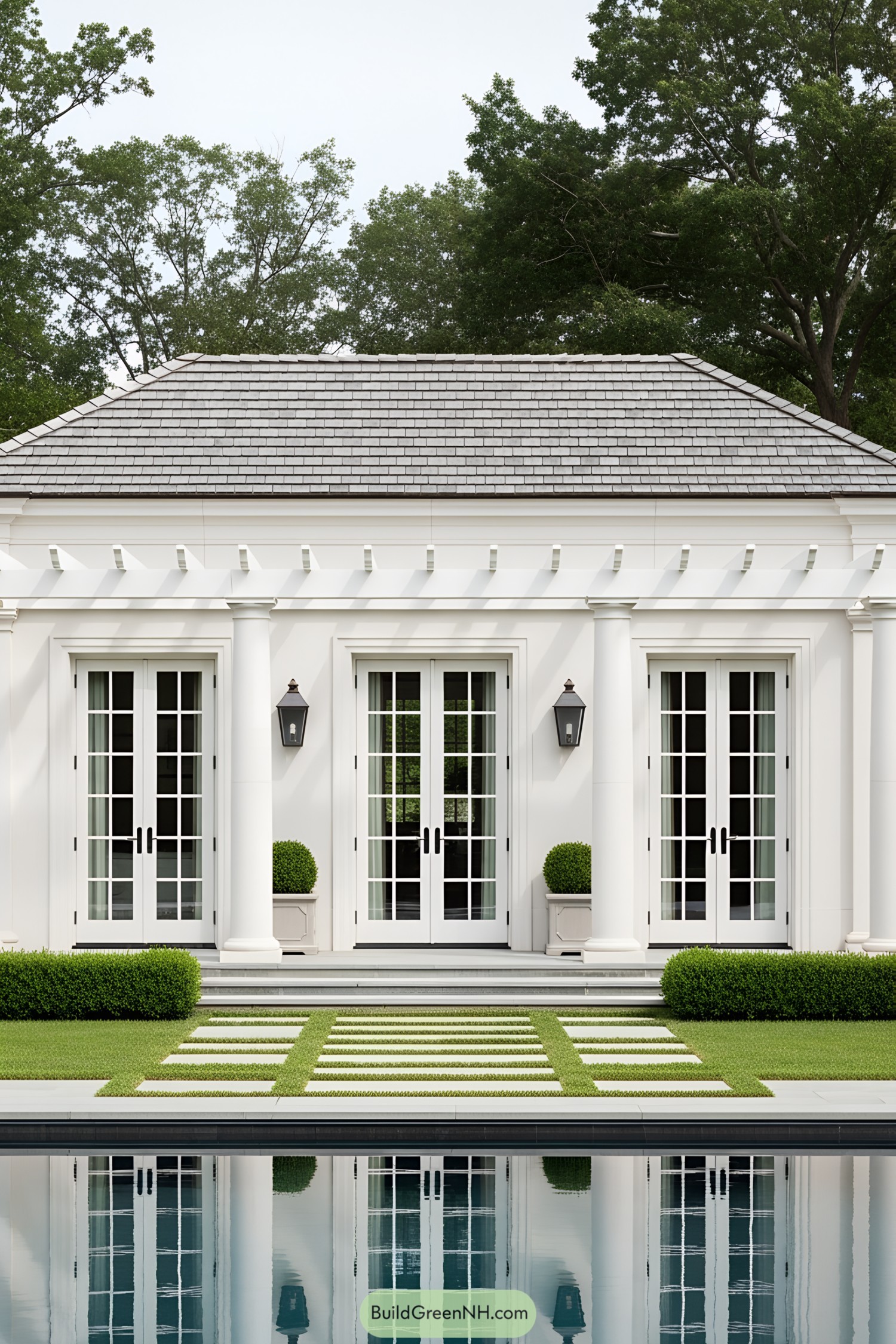 Elegant pool house with French doors and lush greenery