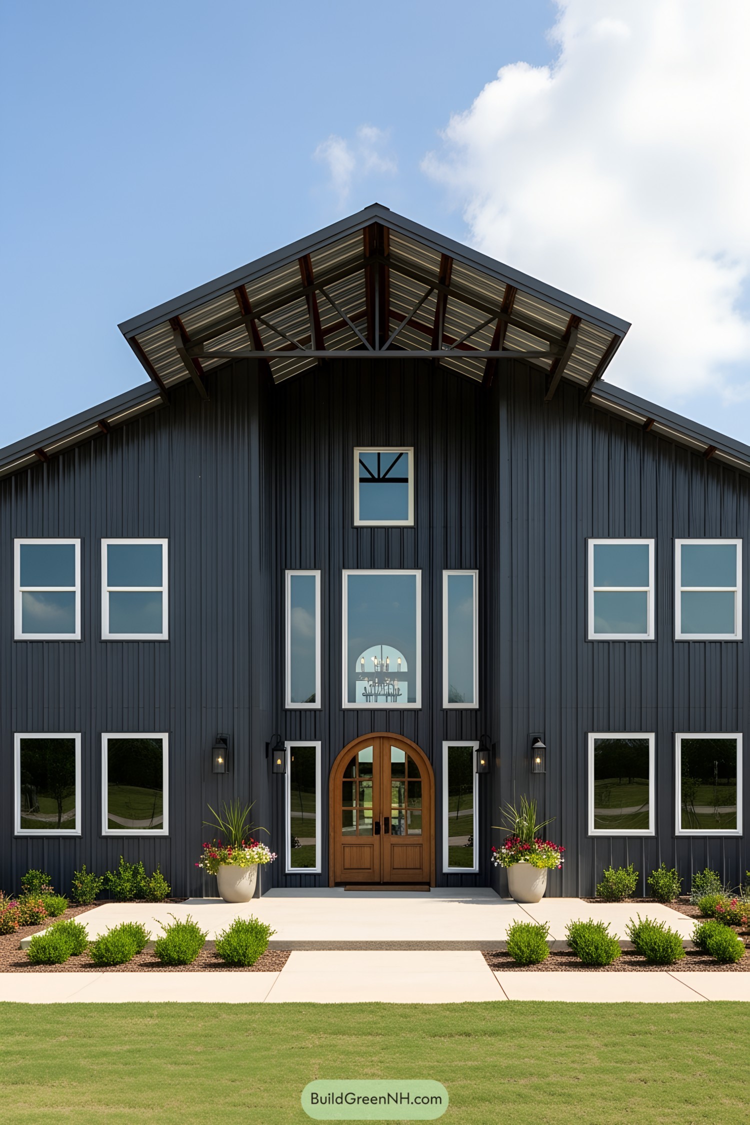 Dark metal exterior with arched wooden door and multiple windows