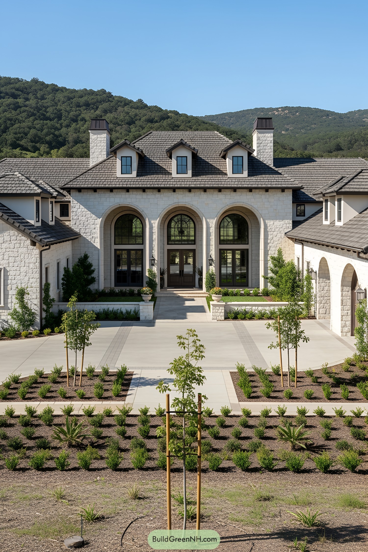 Large stone ranch mansion with grand entrance and lush landscaping
