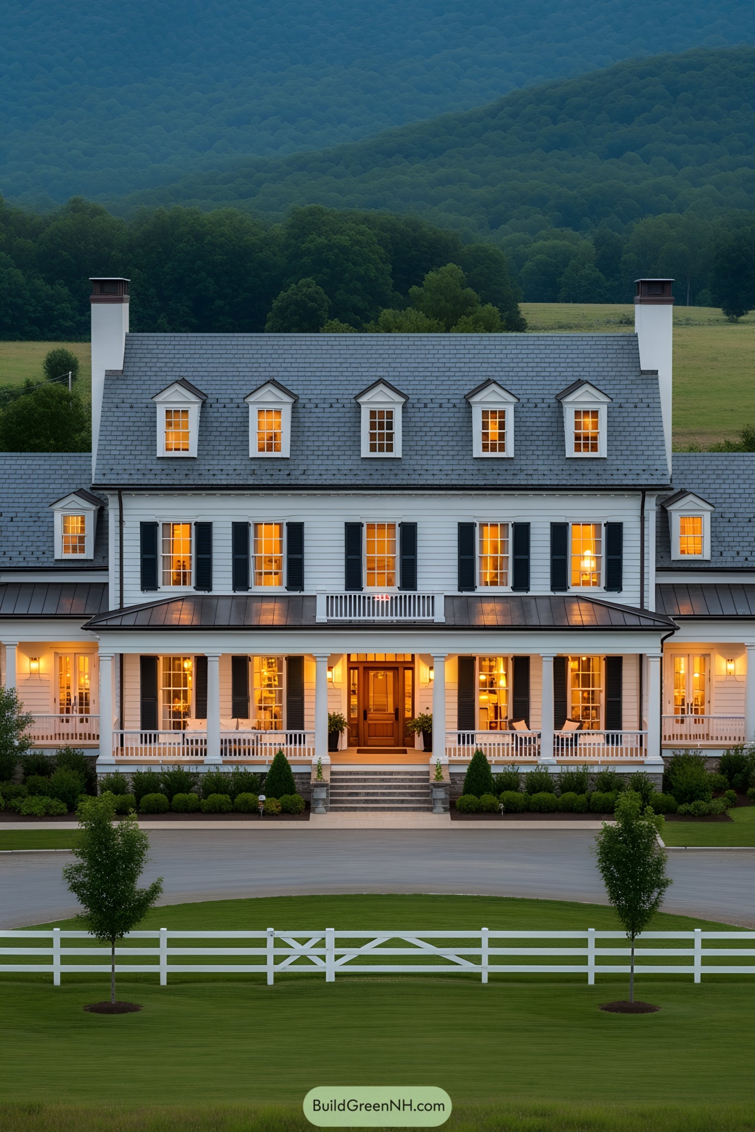 Grand white mansion with glowing windows under a dusky sky
