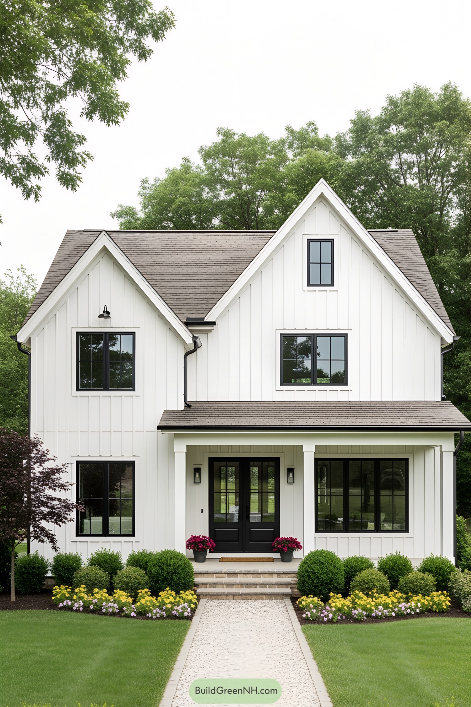 White farmhouse with black accents and lush landscaping