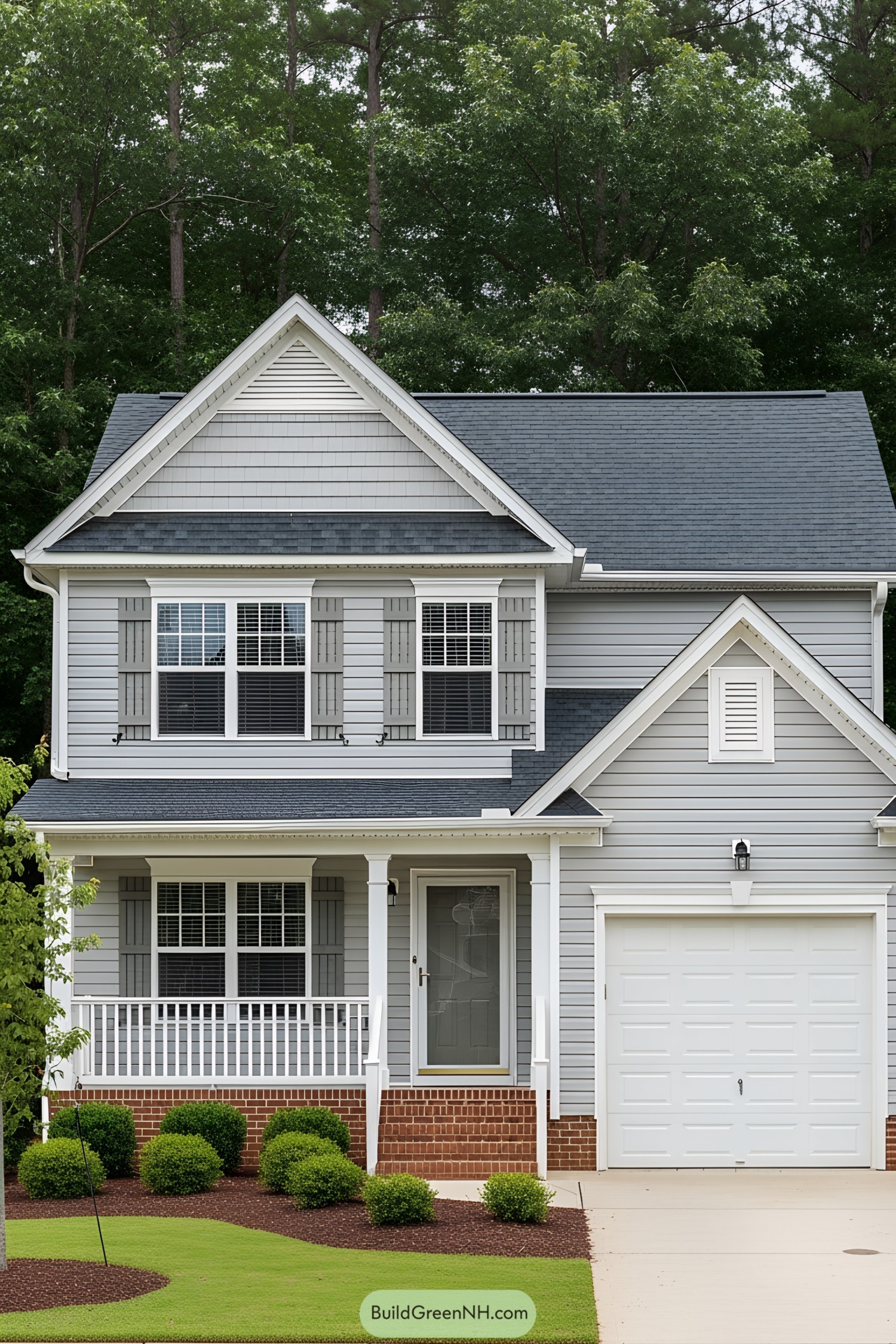 Two-story suburban house with gray siding, brick accents, and a clean white garage