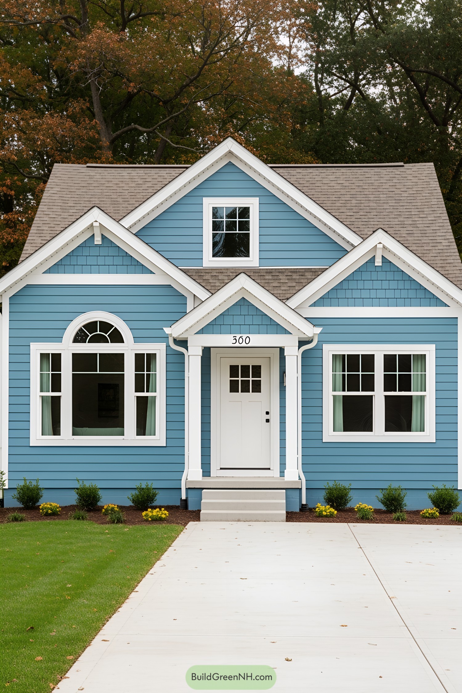 Charming blue suburban house with white trim and a neat front yard
