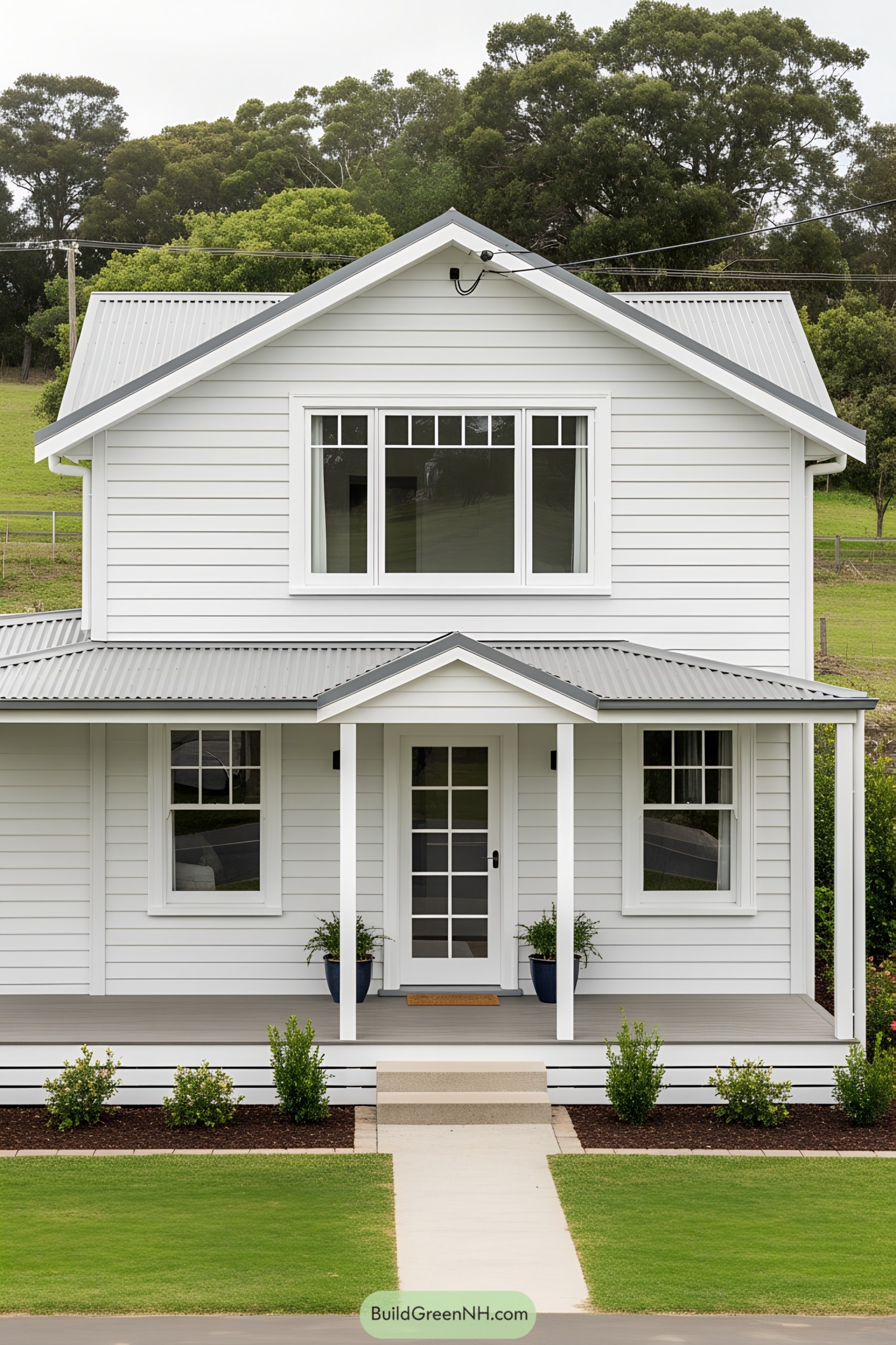 Small white house with a simple porch and lush surroundings