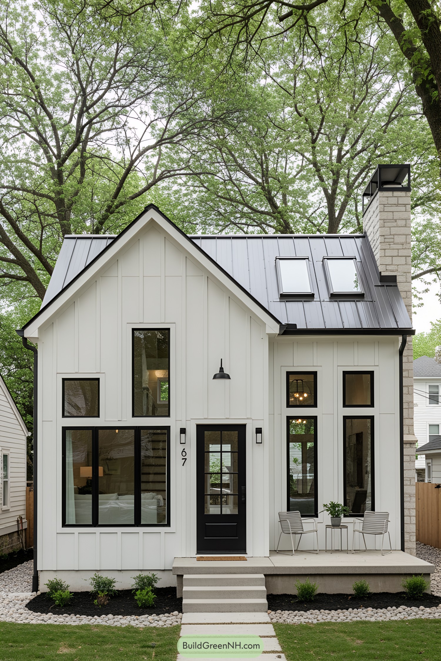 Small white house with black accents surrounded by trees