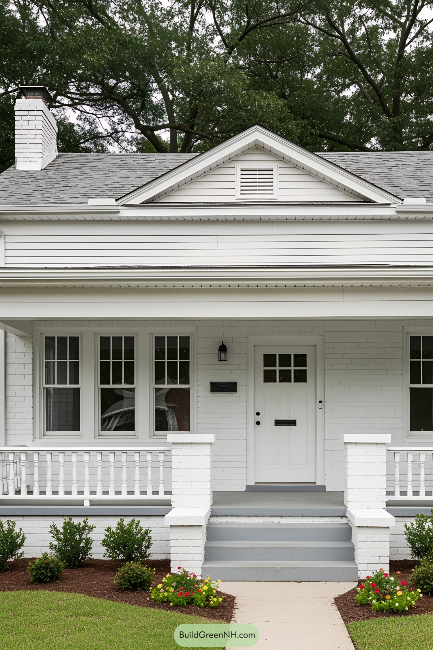 Front view of a charming white cottage with a porch