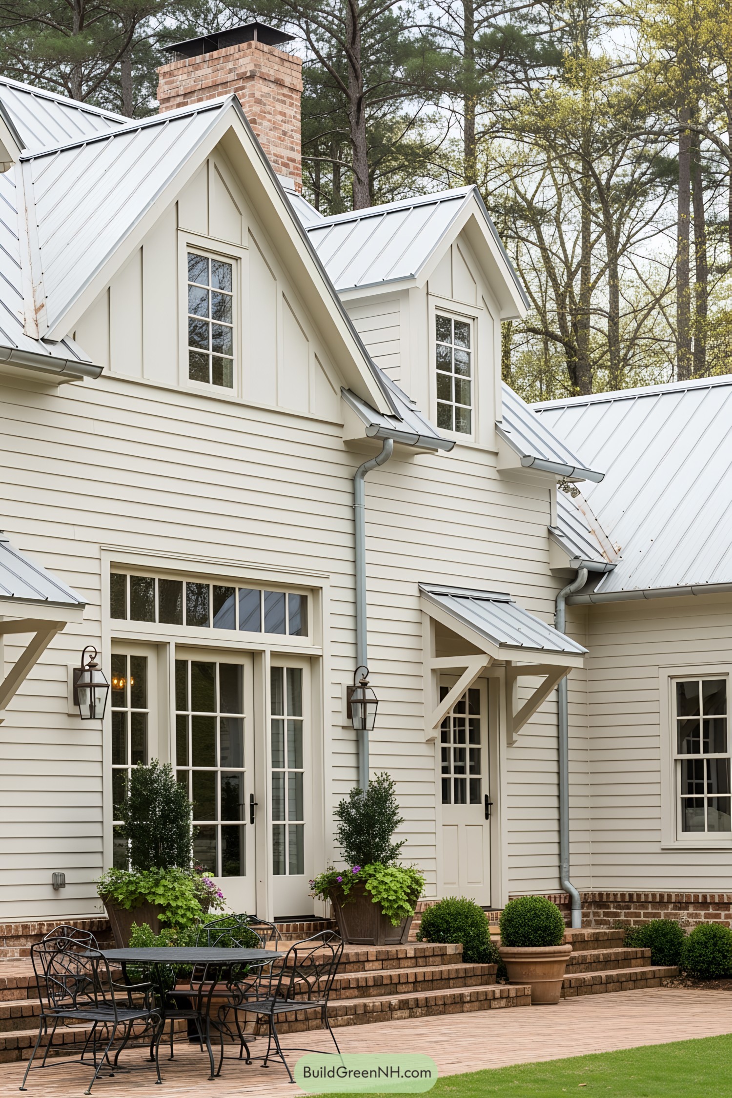 Cream-colored farmhouse with dormers and a metal roof