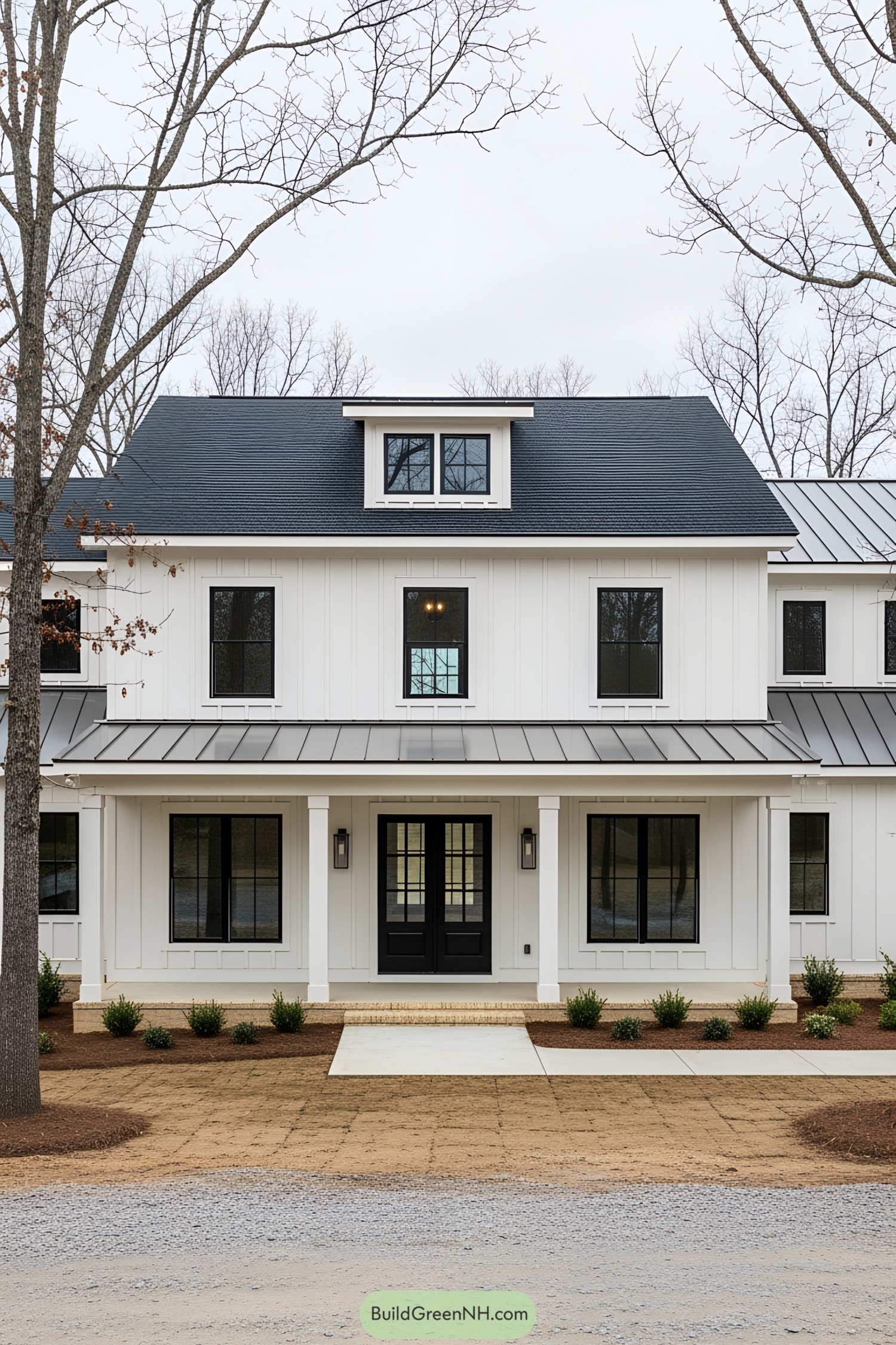 A charming white farmhouse with a black roof and inviting porch