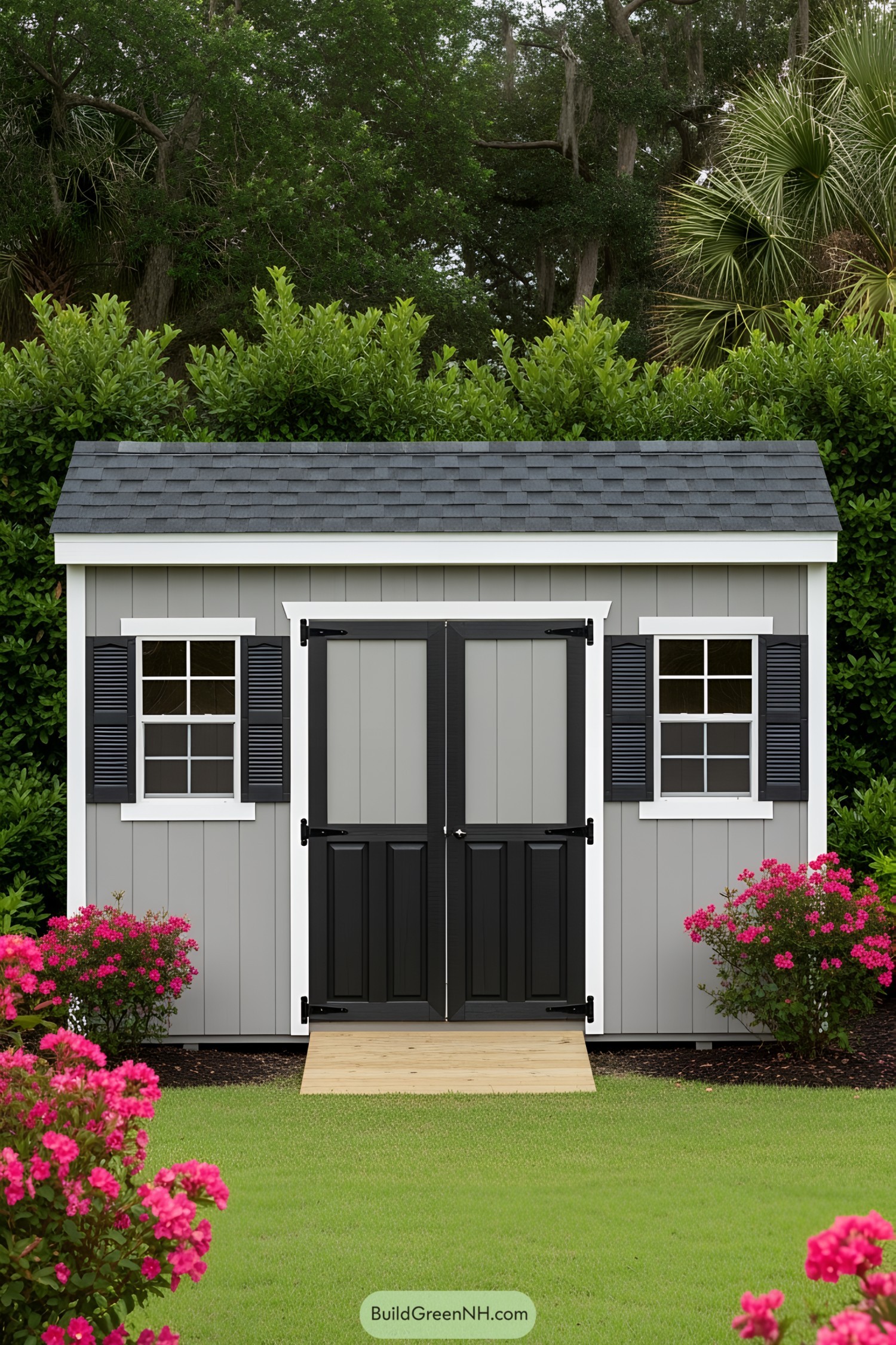 Gray storage shed with black doors, windows, and floral landscaping