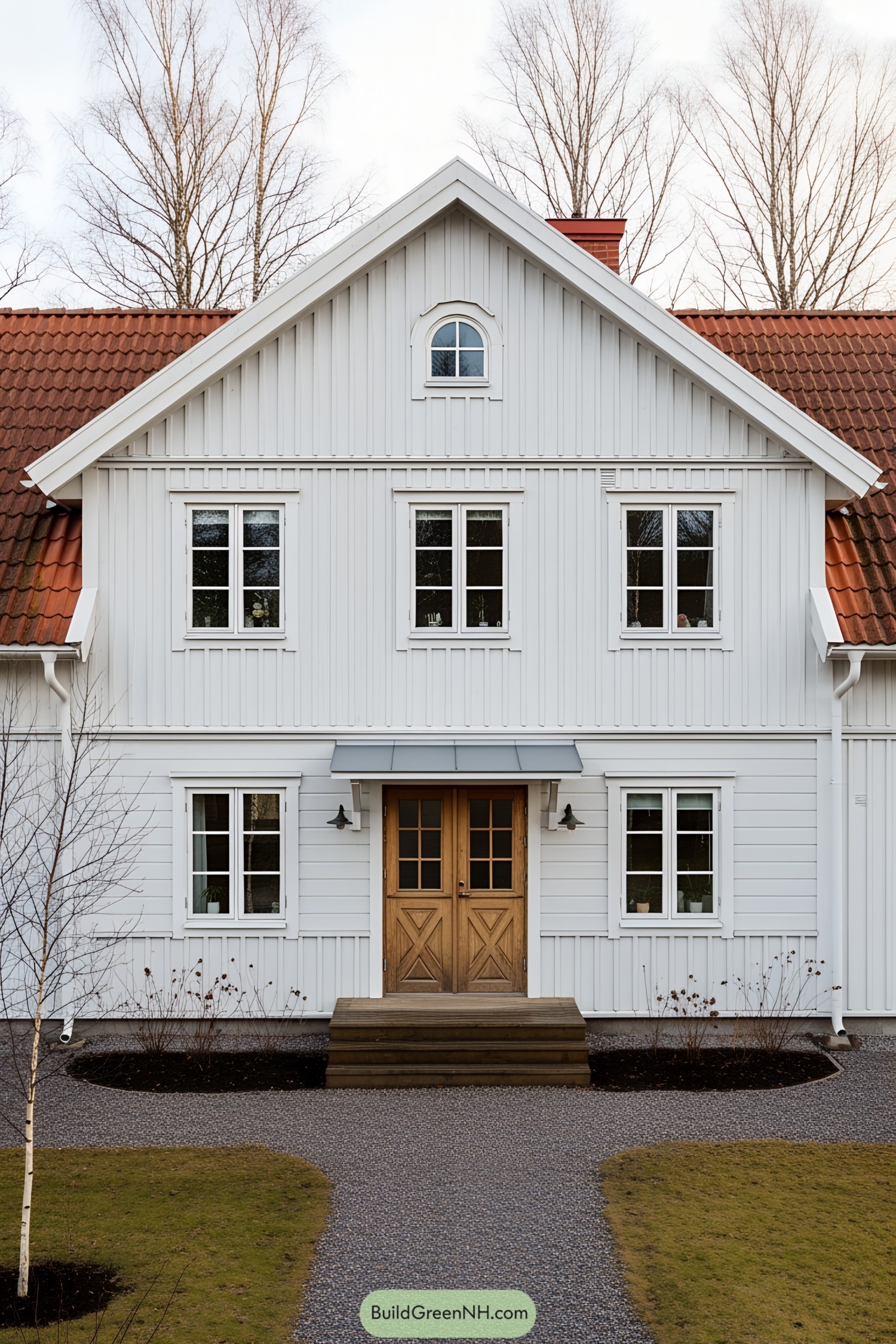 White farmhouse with brown roof and wooden doors