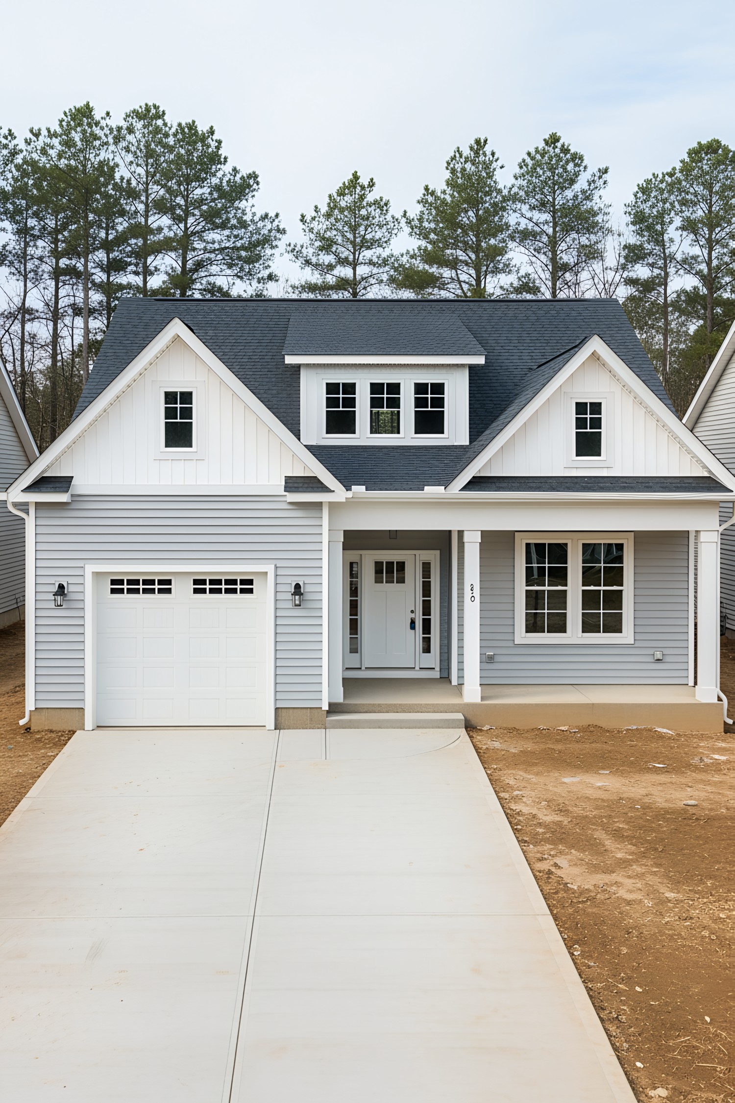 Gray cottage with a white garage and long driveway
