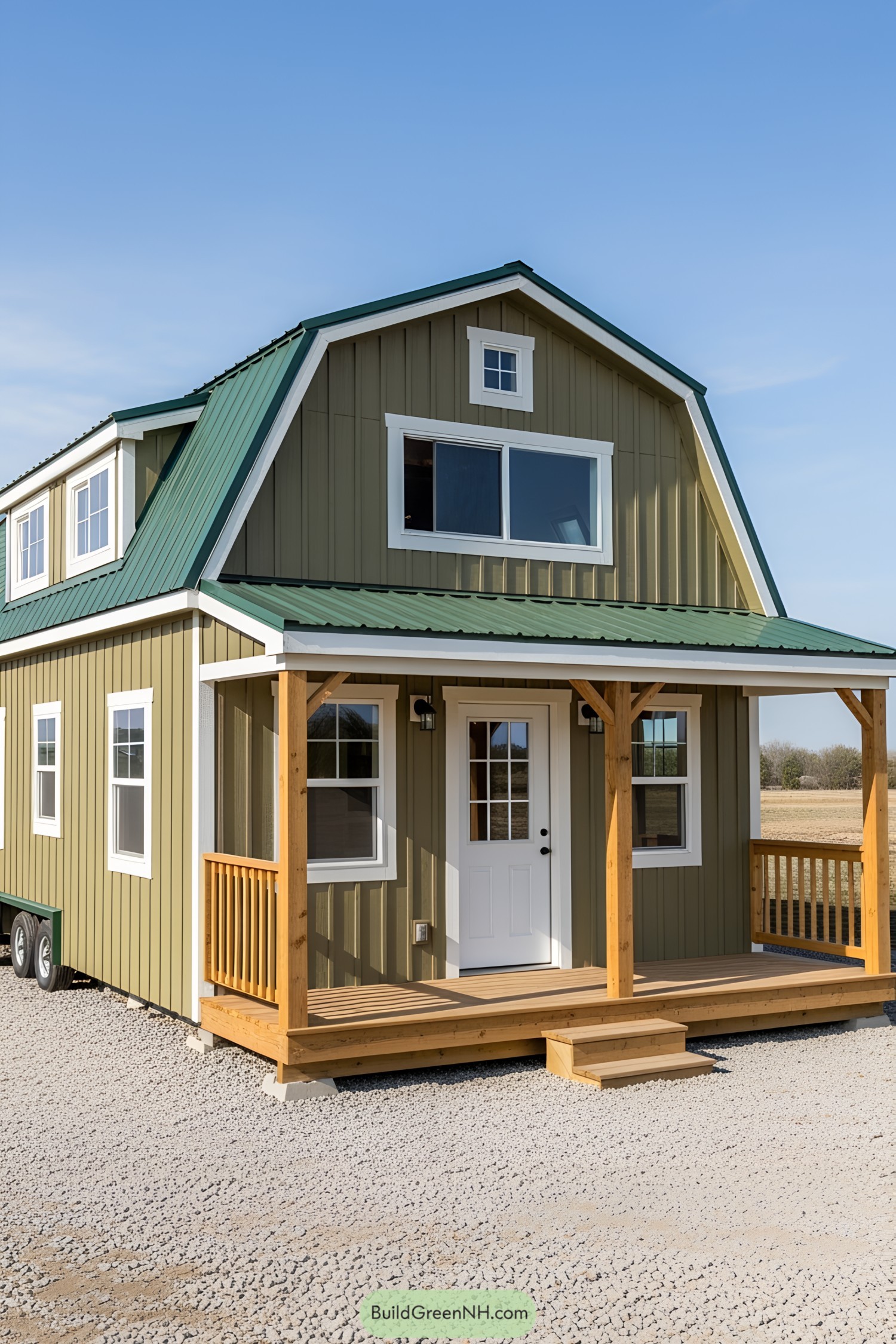Tiny house with olive green siding and a green gambrel roof