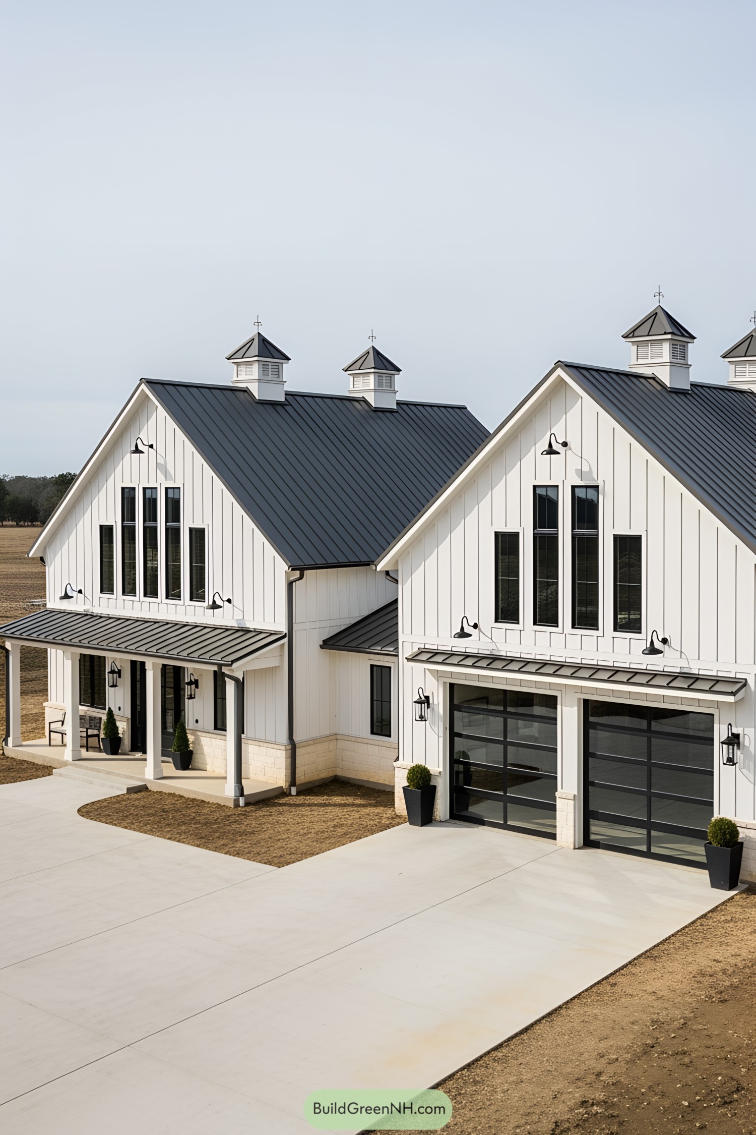 White barn-style mansion with black roof and large windows