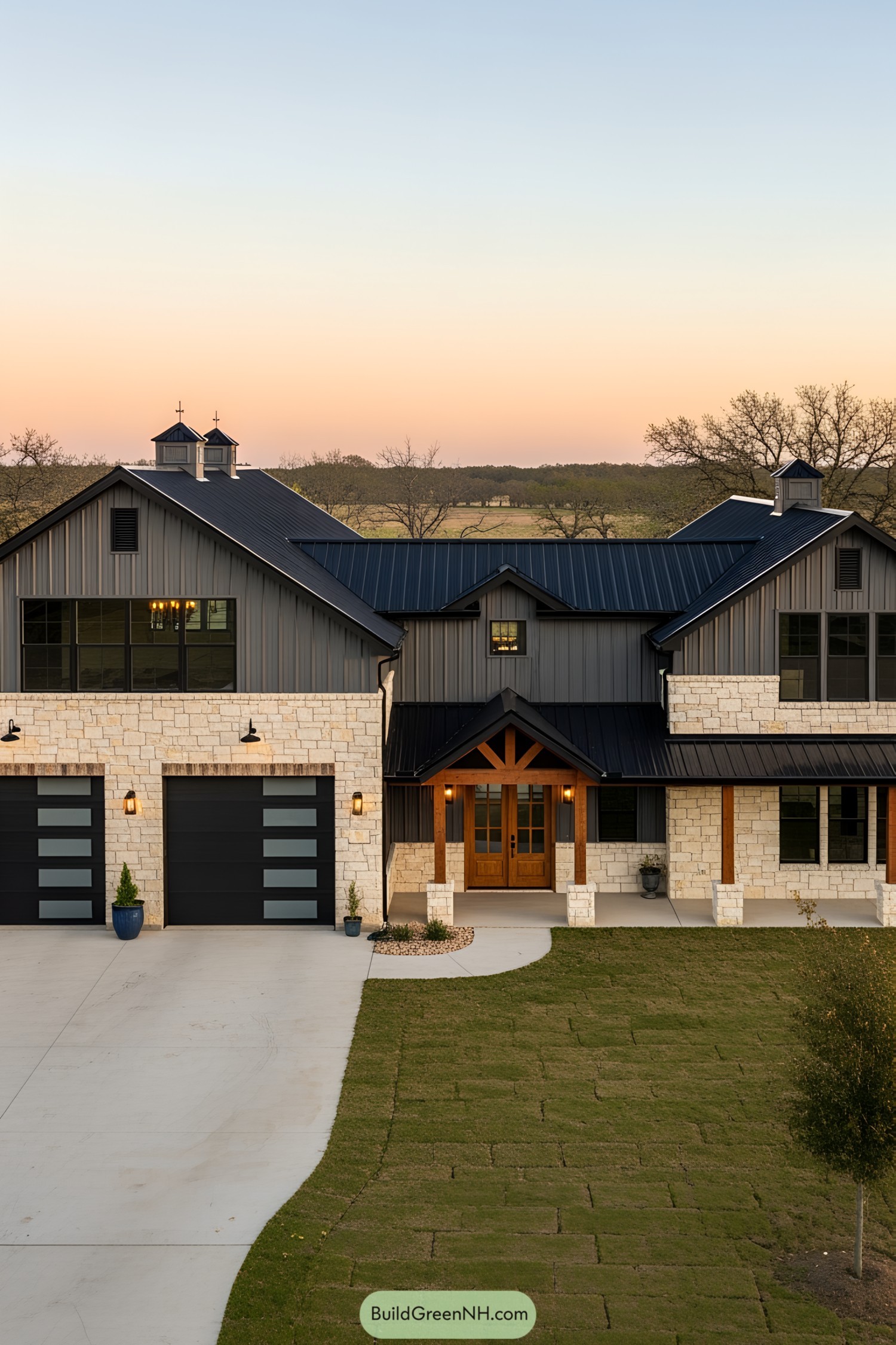 A striking barn-style mansion with a sunset backdrop
