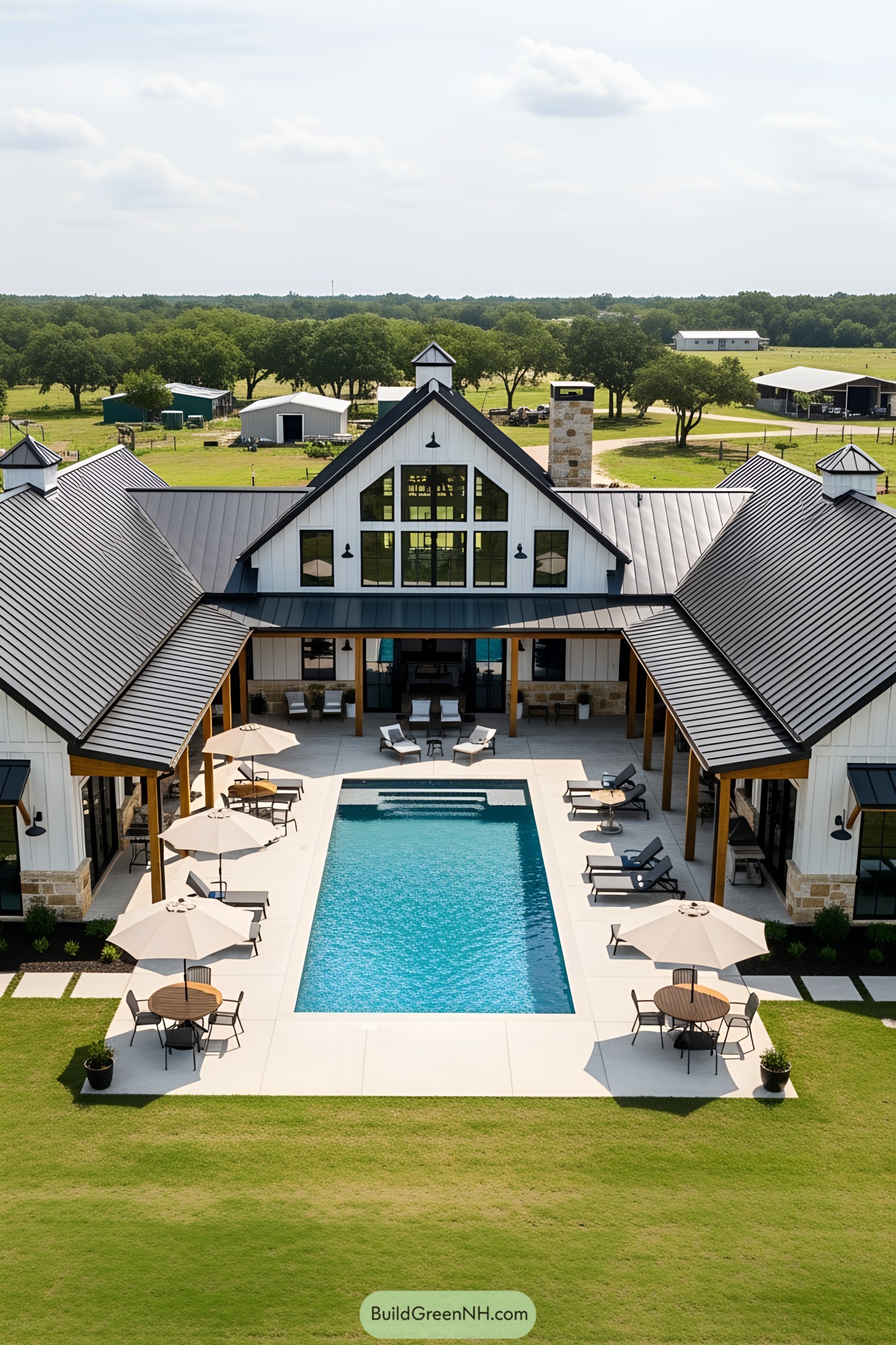 Barndominium with a pool surrounded by loungers and umbrellas