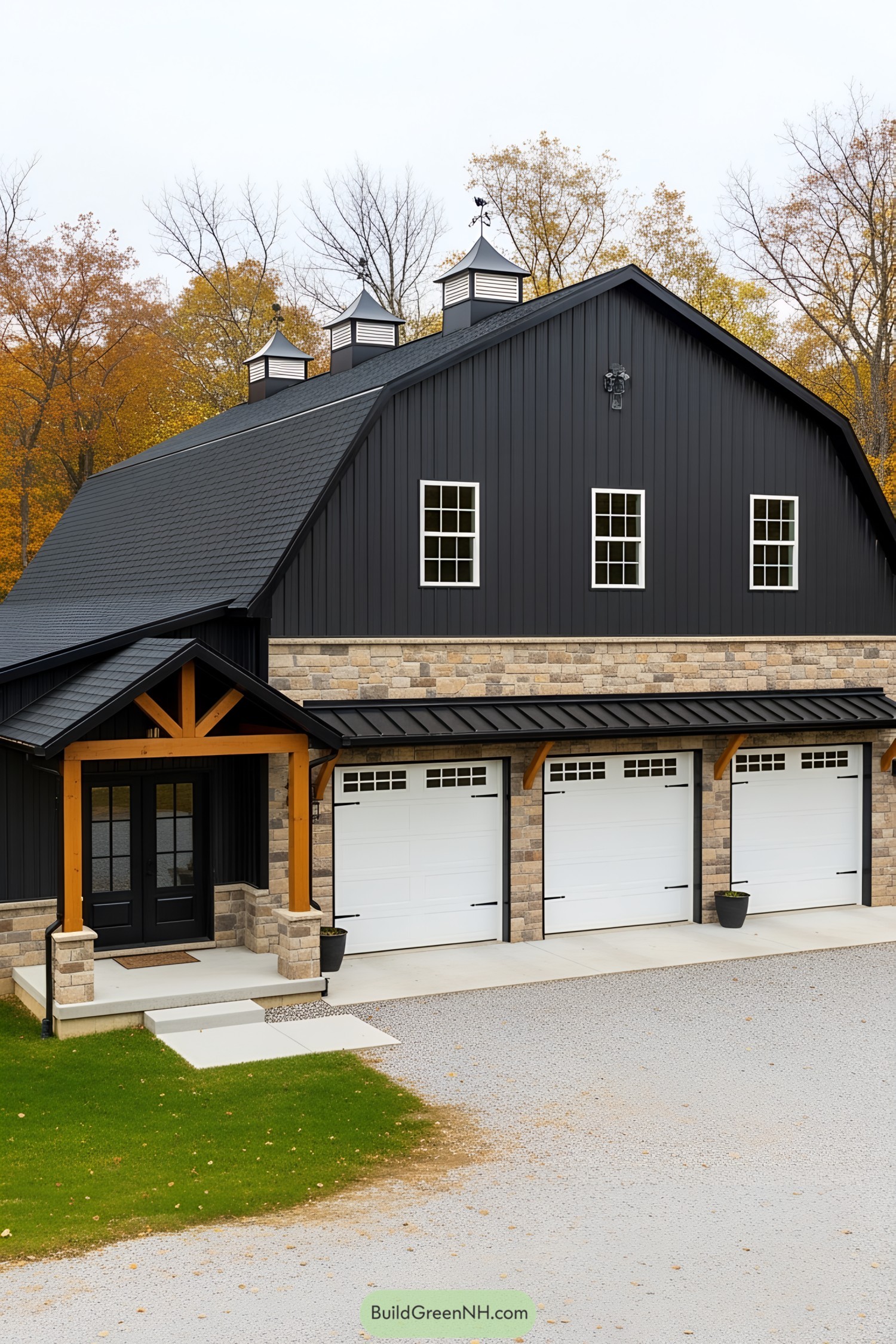Black barndominium with stone accents and a triple garage