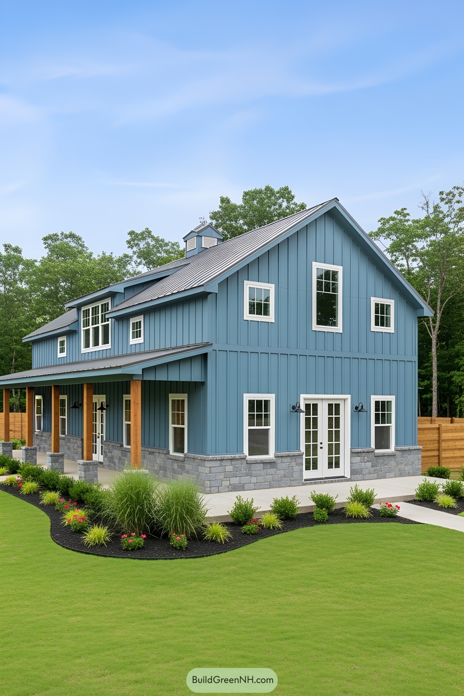 A charming blue barndominium against a lush green backdrop