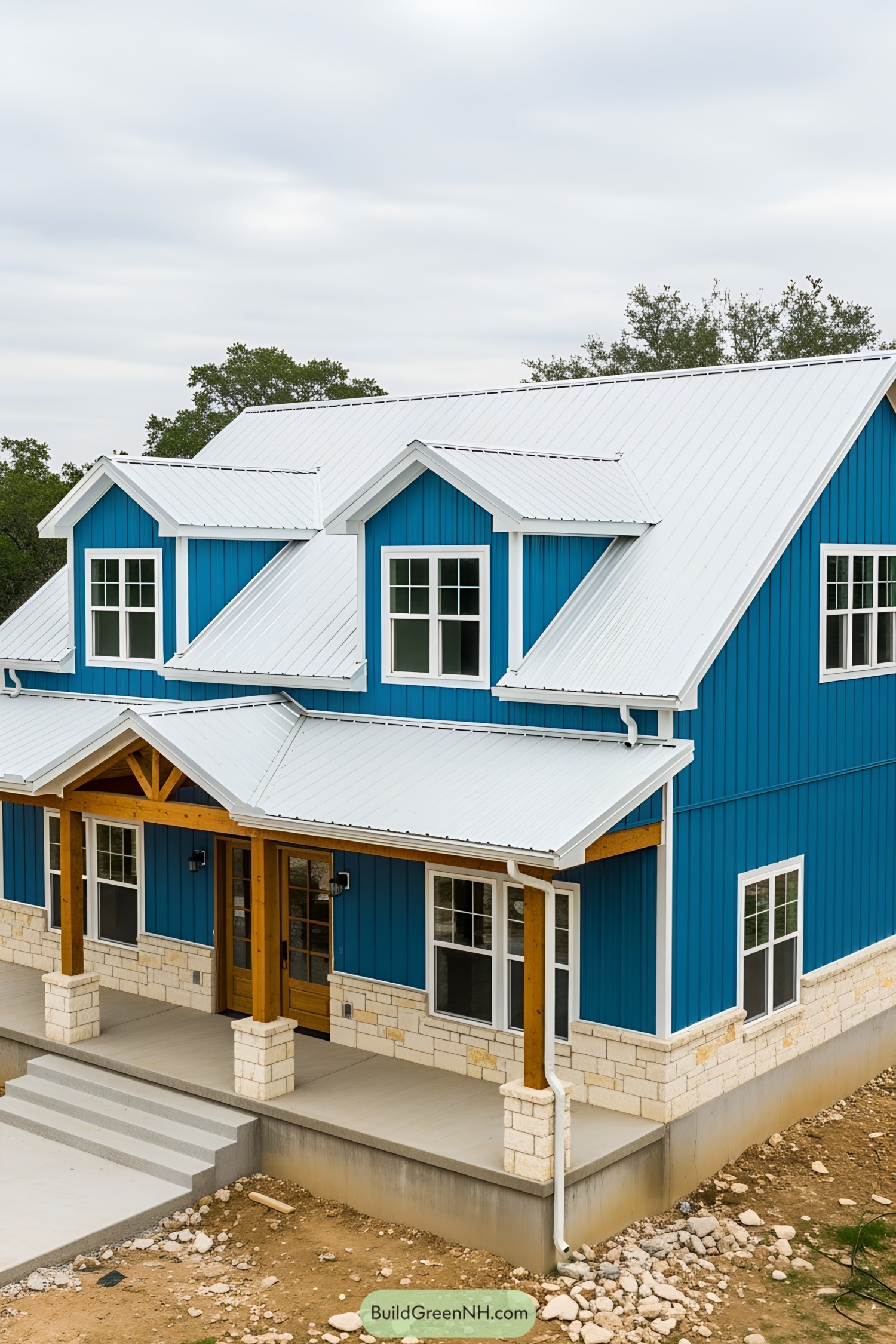 A bright blue barndominium with a white roof and wooden accents