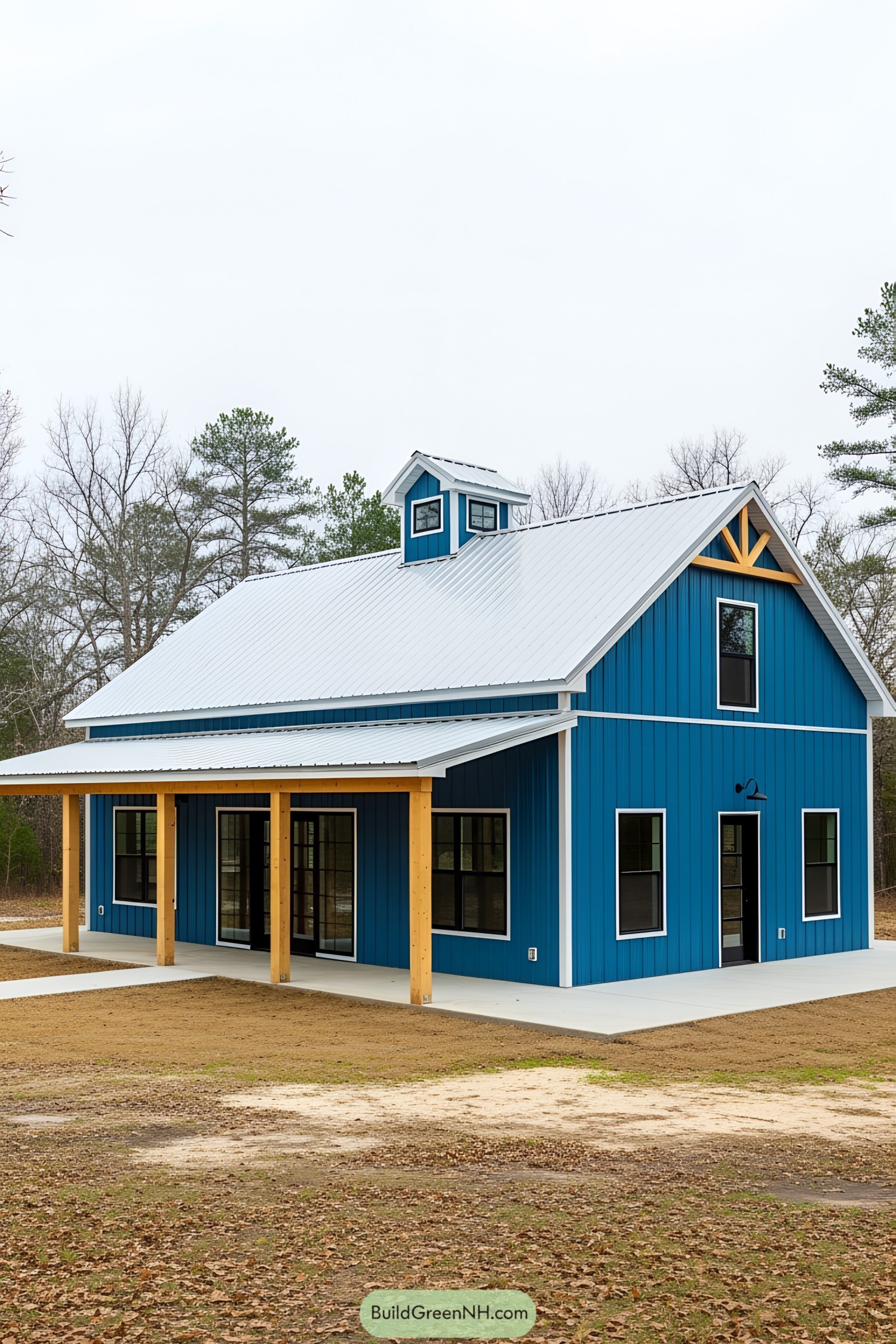 A vibrant blue barndominium with a contrasting white roof