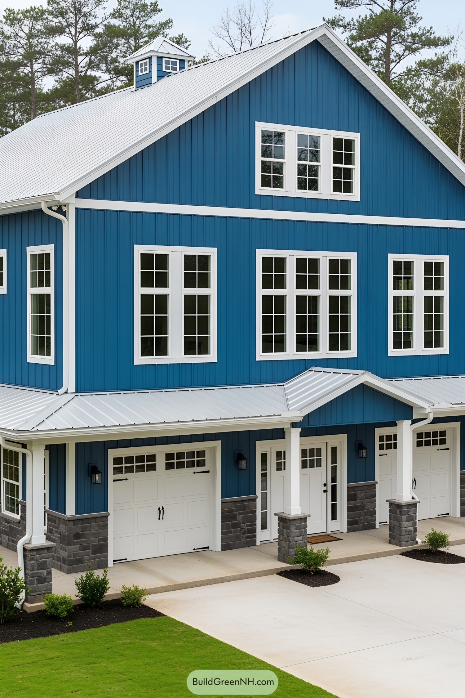 Blue barndominium with white trim and large windows