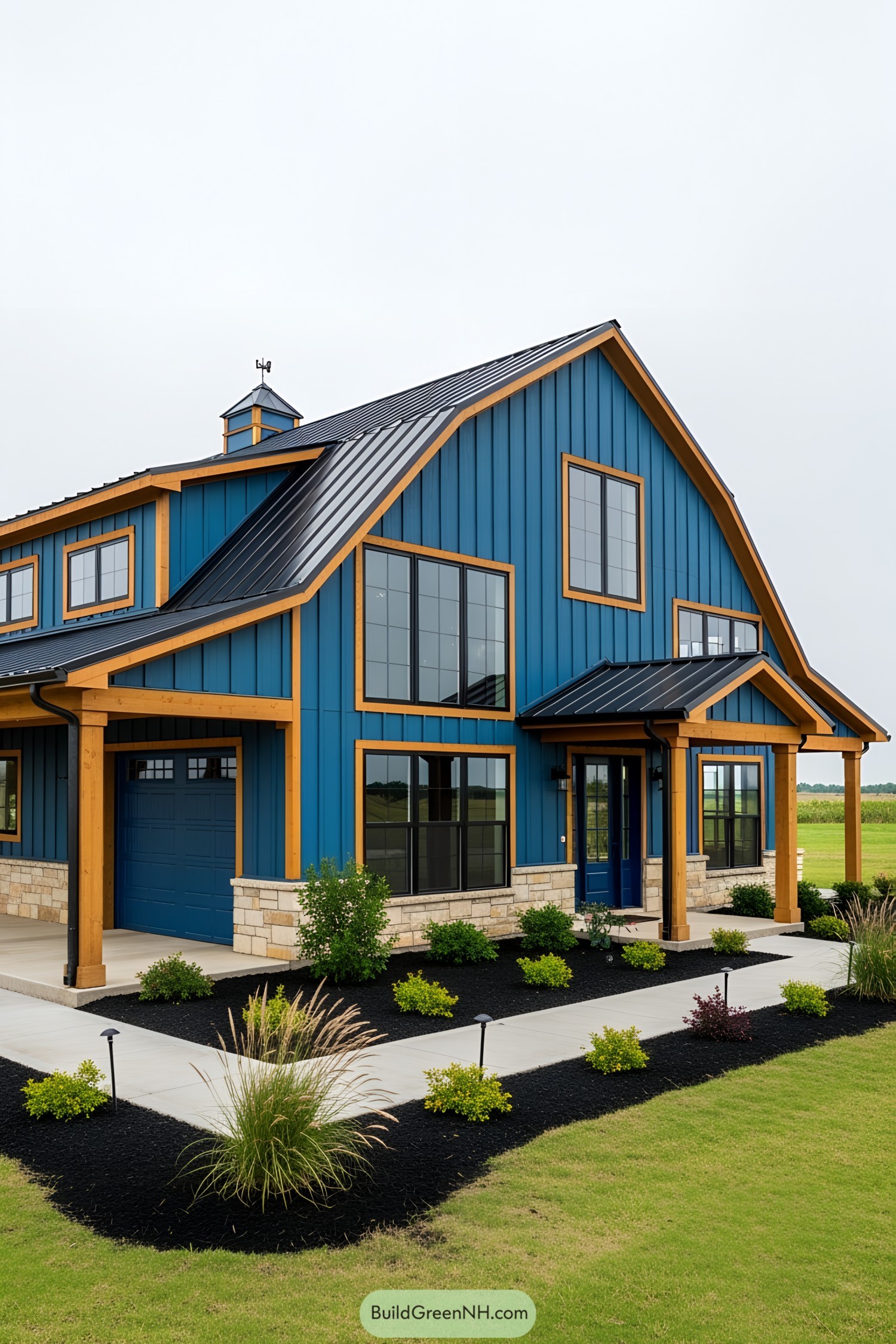 A striking blue barndominium with wooden trim and modern landscaping