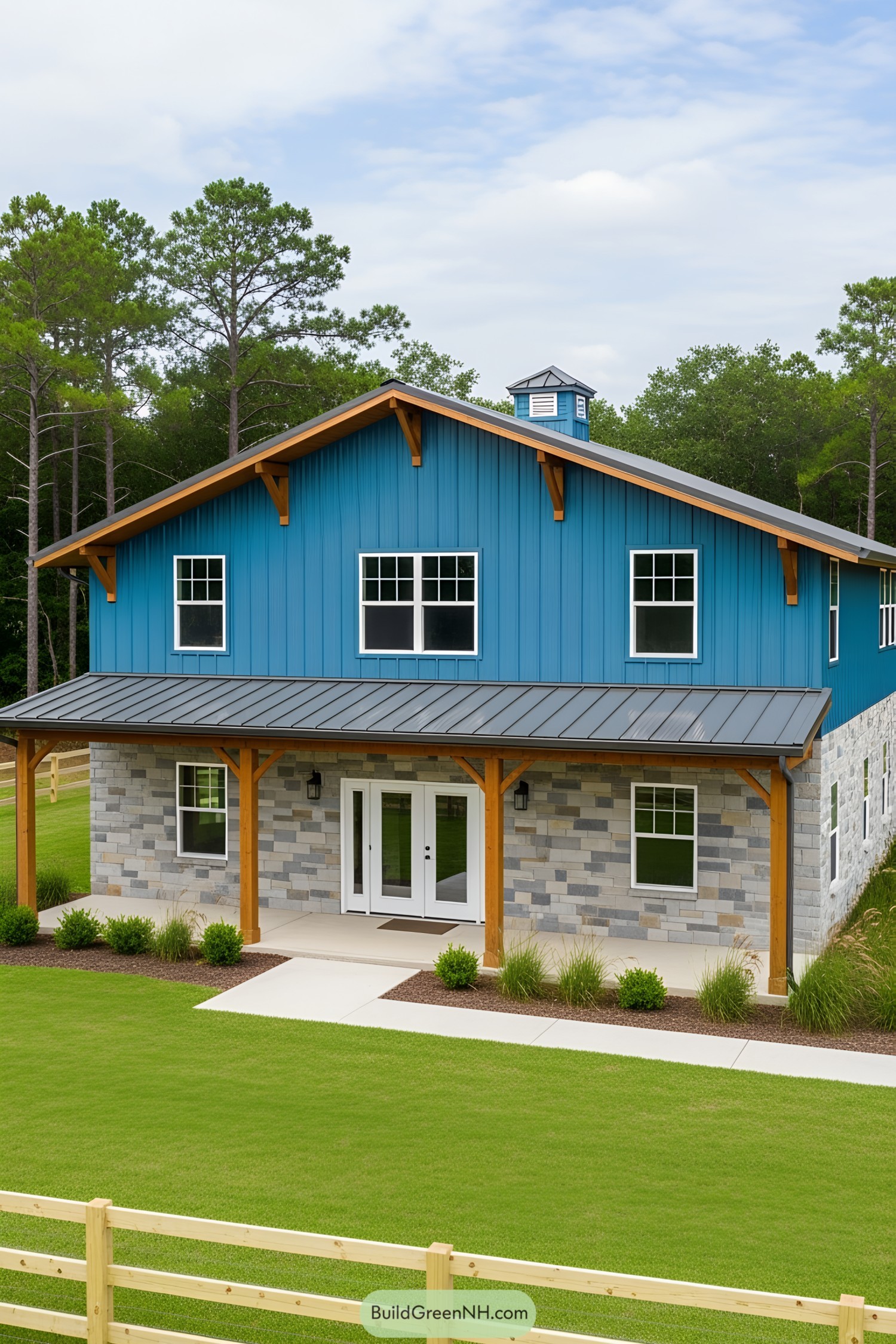 A modern blue barndominium with lush landscaping