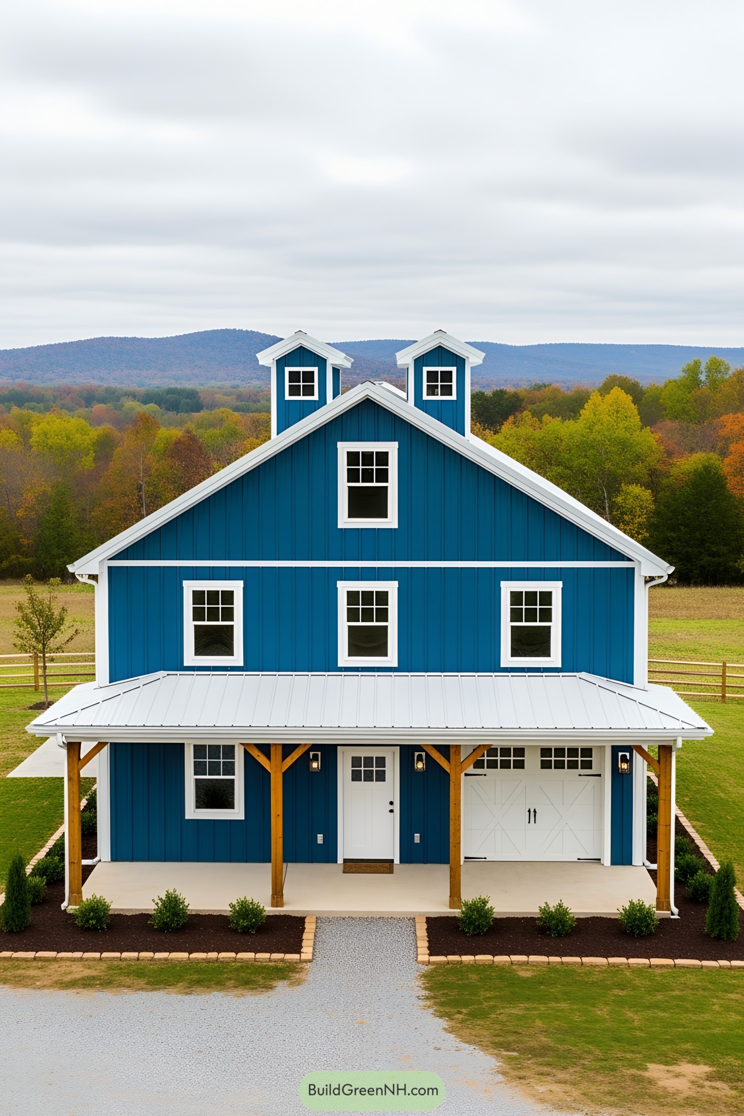 Striking blue barndominium with mountain backdrop