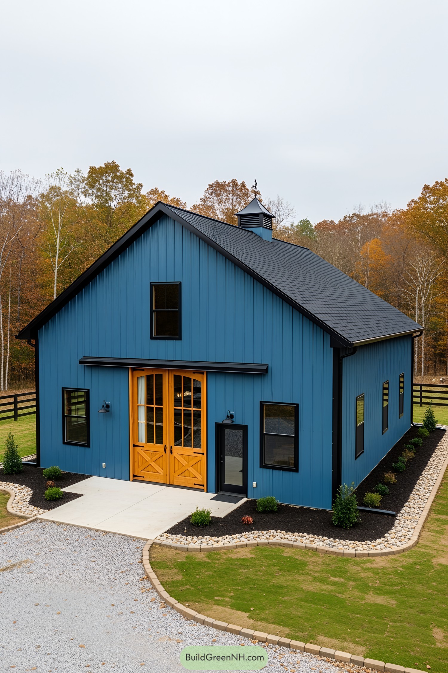 Blue barndominium with wooden accents and a black roof