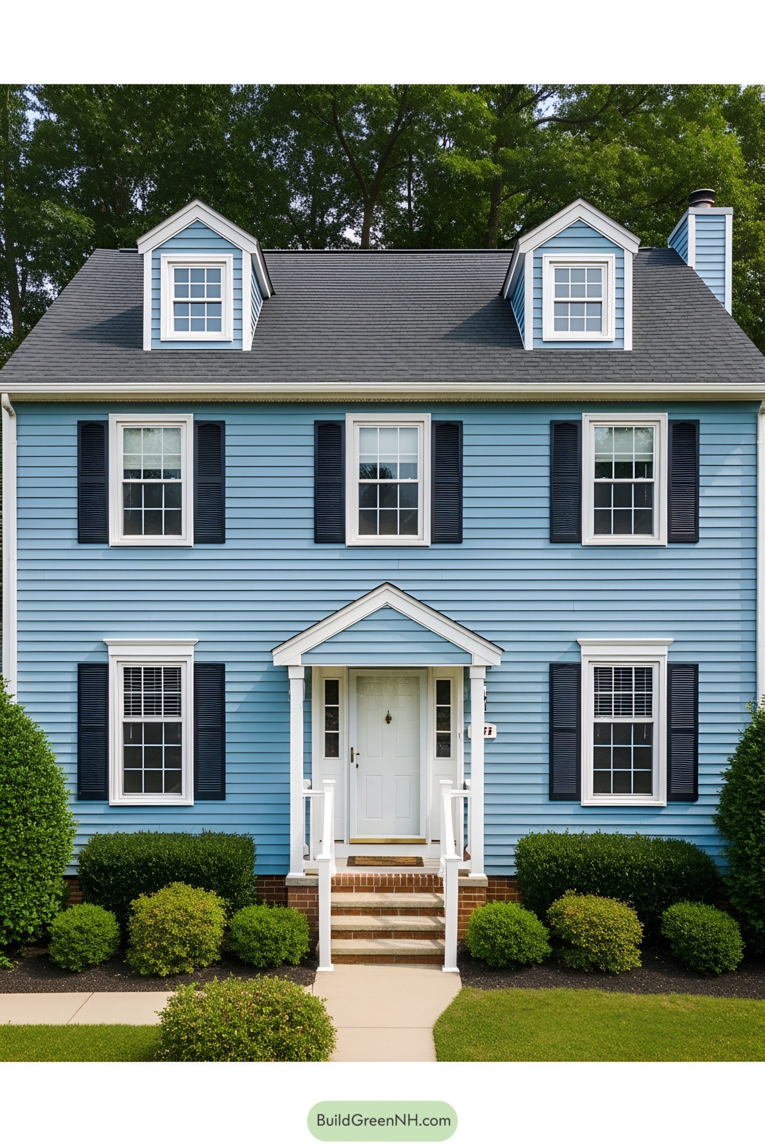 Charming light-blue suburban house with white trim surrounded by greenery