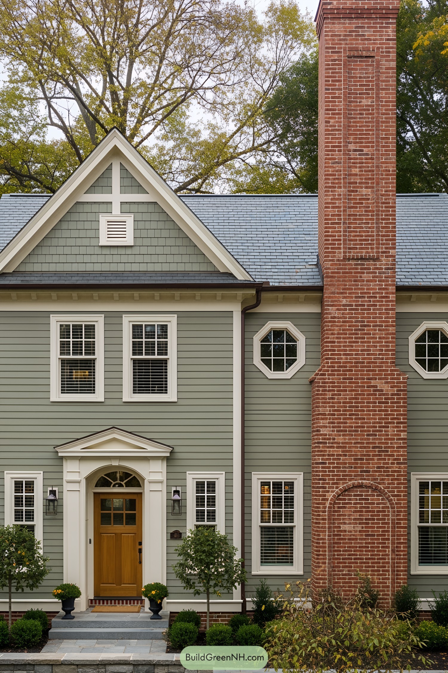 Green siding house with red brick chimney