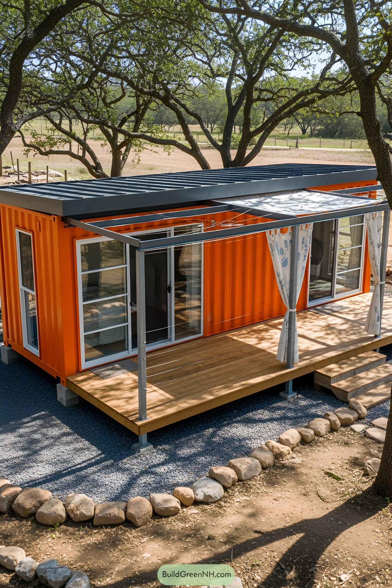 Vibrant orange container studio with a deck, surrounded by trees