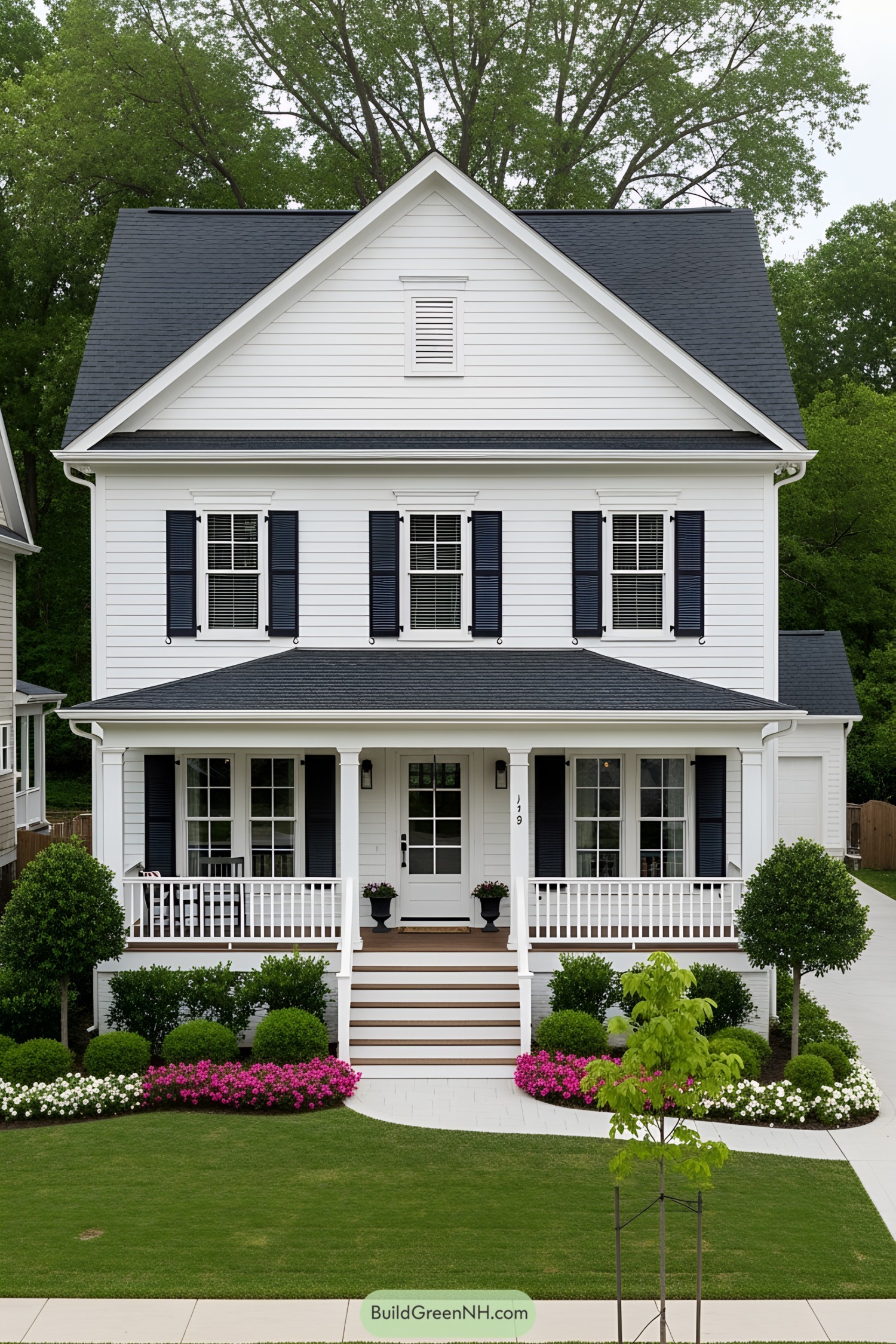 White two-story house with a front porch and colorful garden