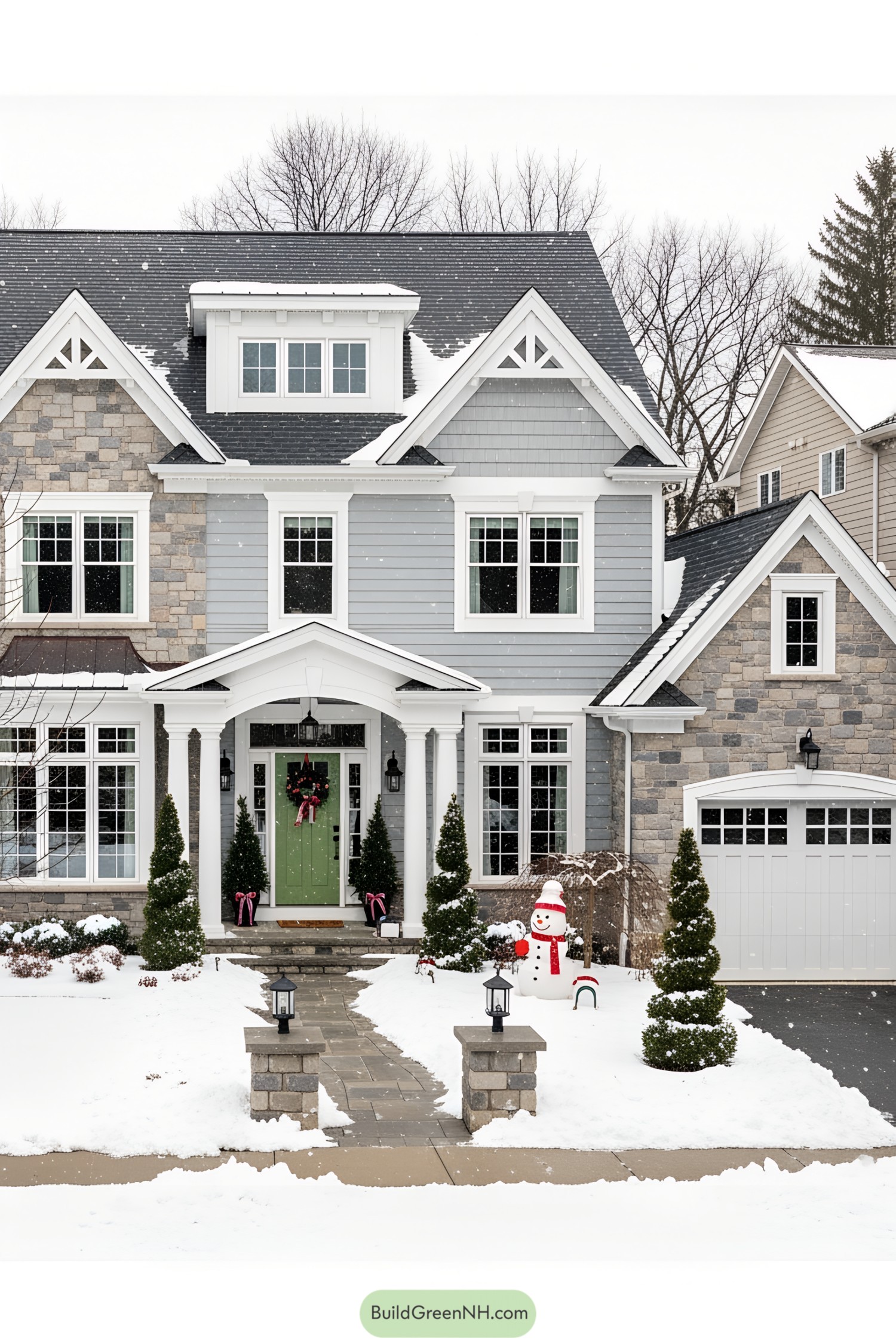 Snow-covered house with festive decorations and a snowman