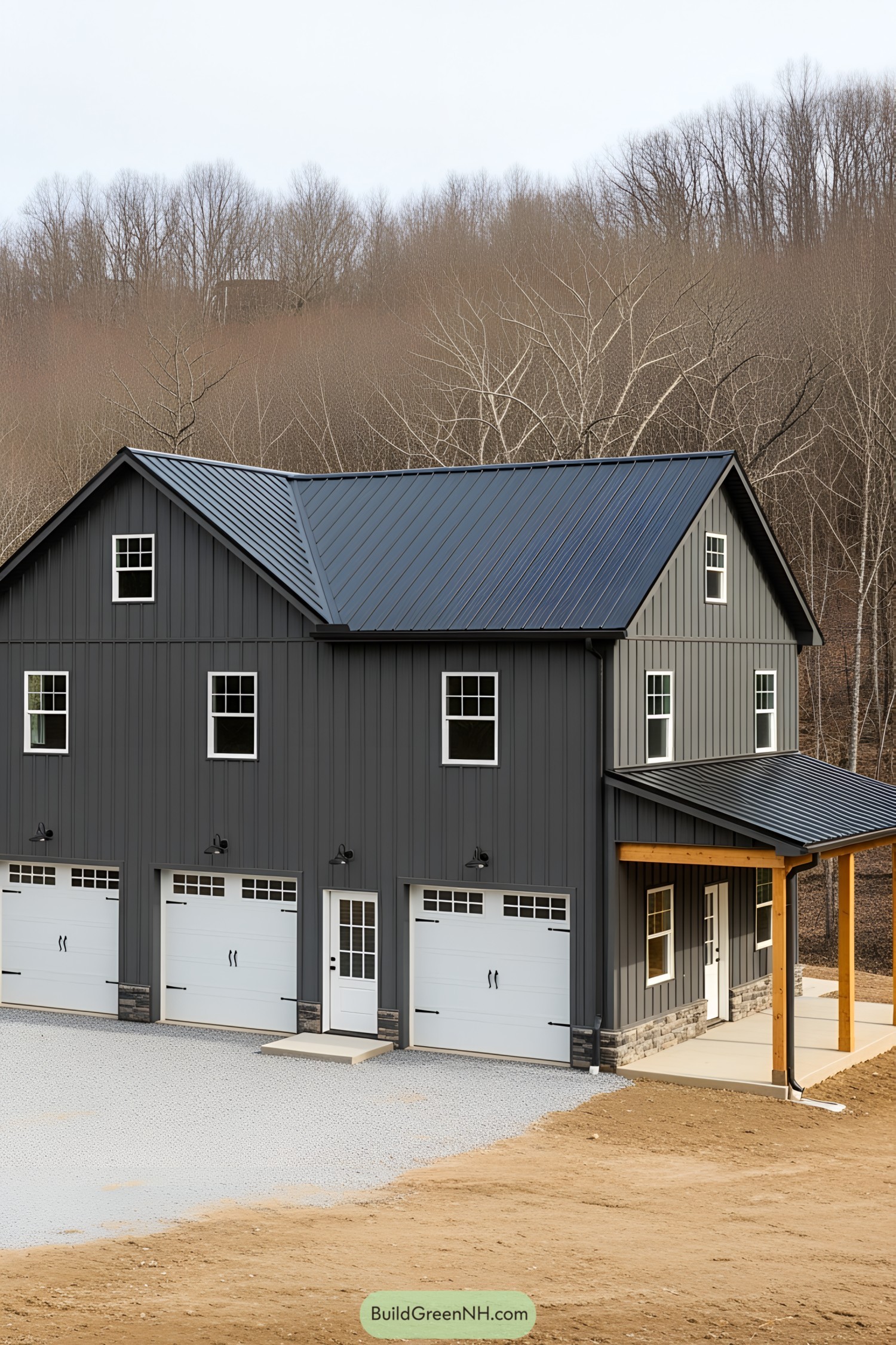 Dark gray barn house with white garage doors