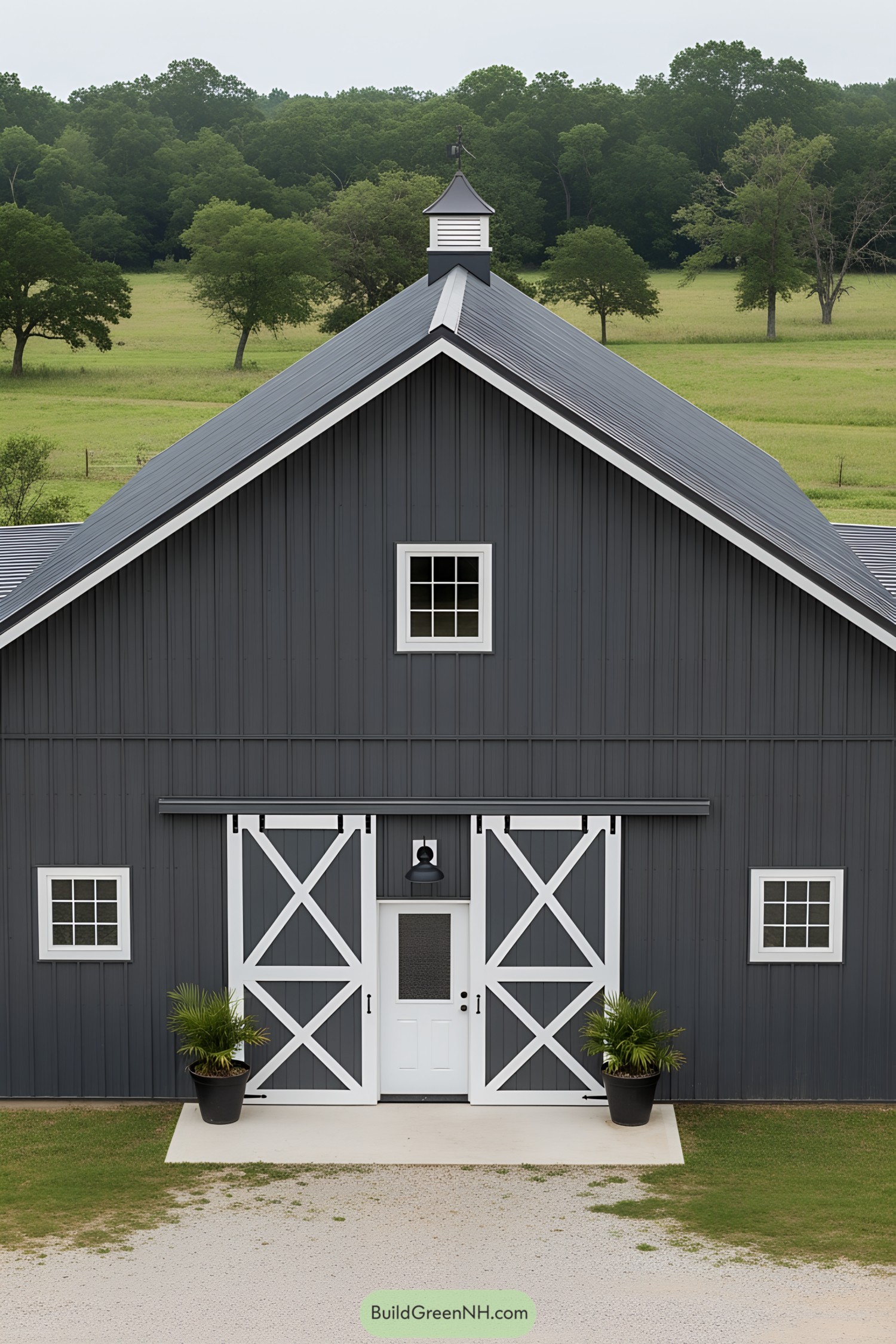 Dark gray barn with white trim in a green landscape
