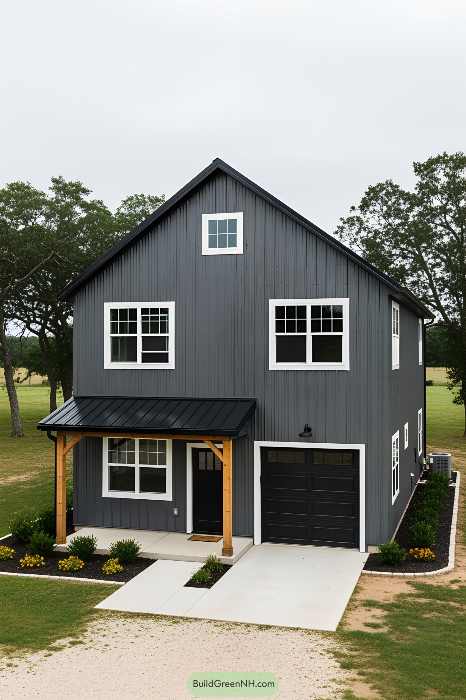 A dark gray barn house with white-trimmed windows and a cozy porch