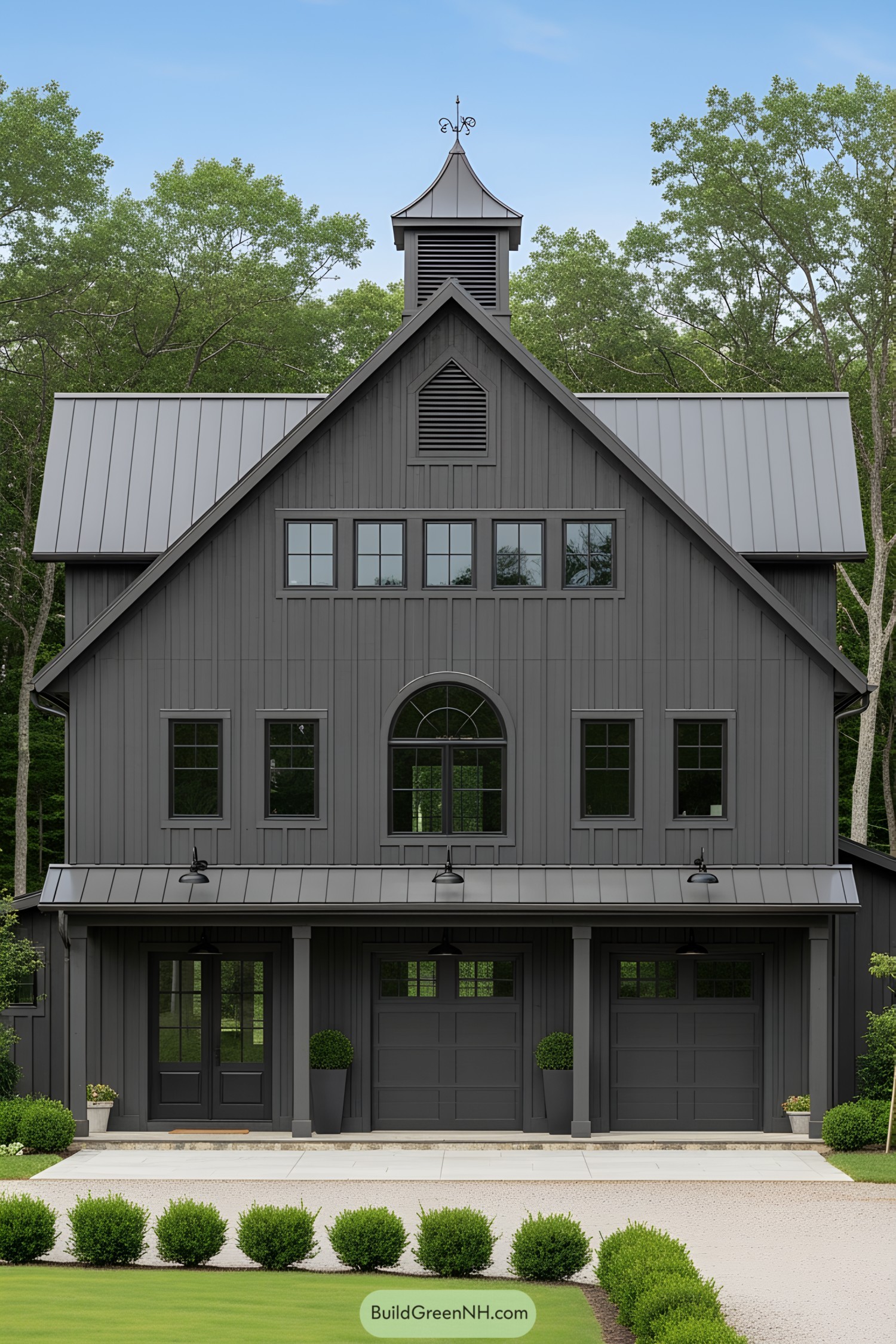 Dark gray barn house with metal roof and cupola