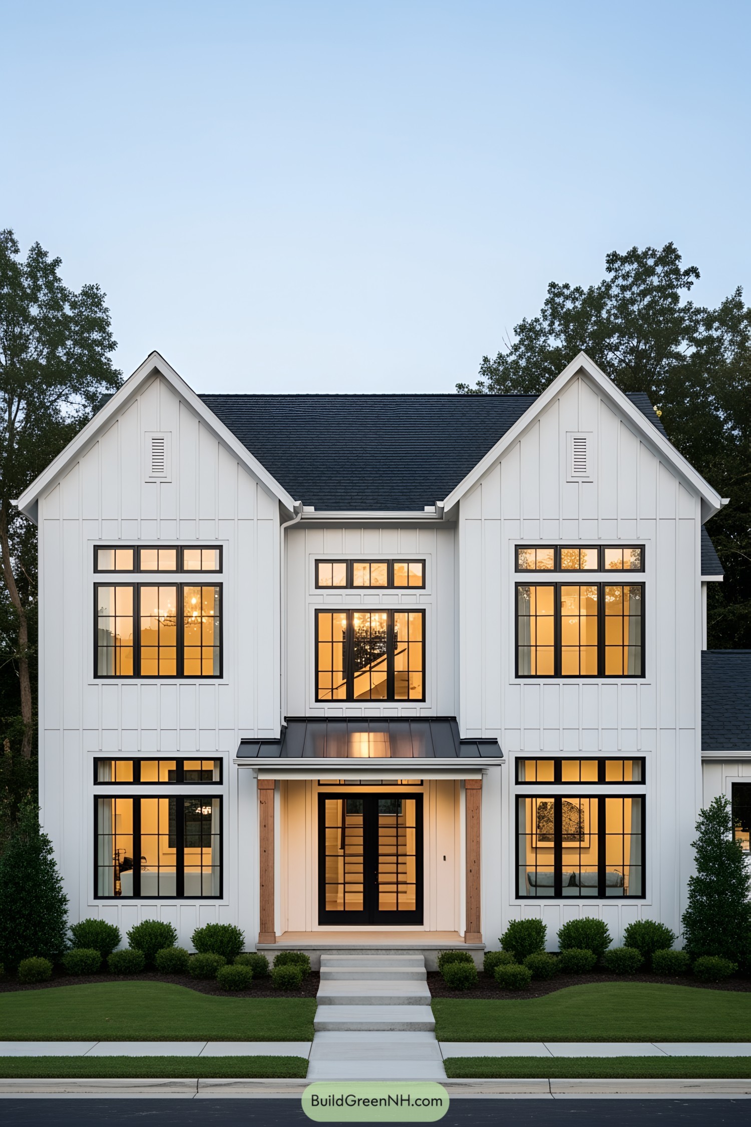 Modern white farmhouse with black window frames and green lawn