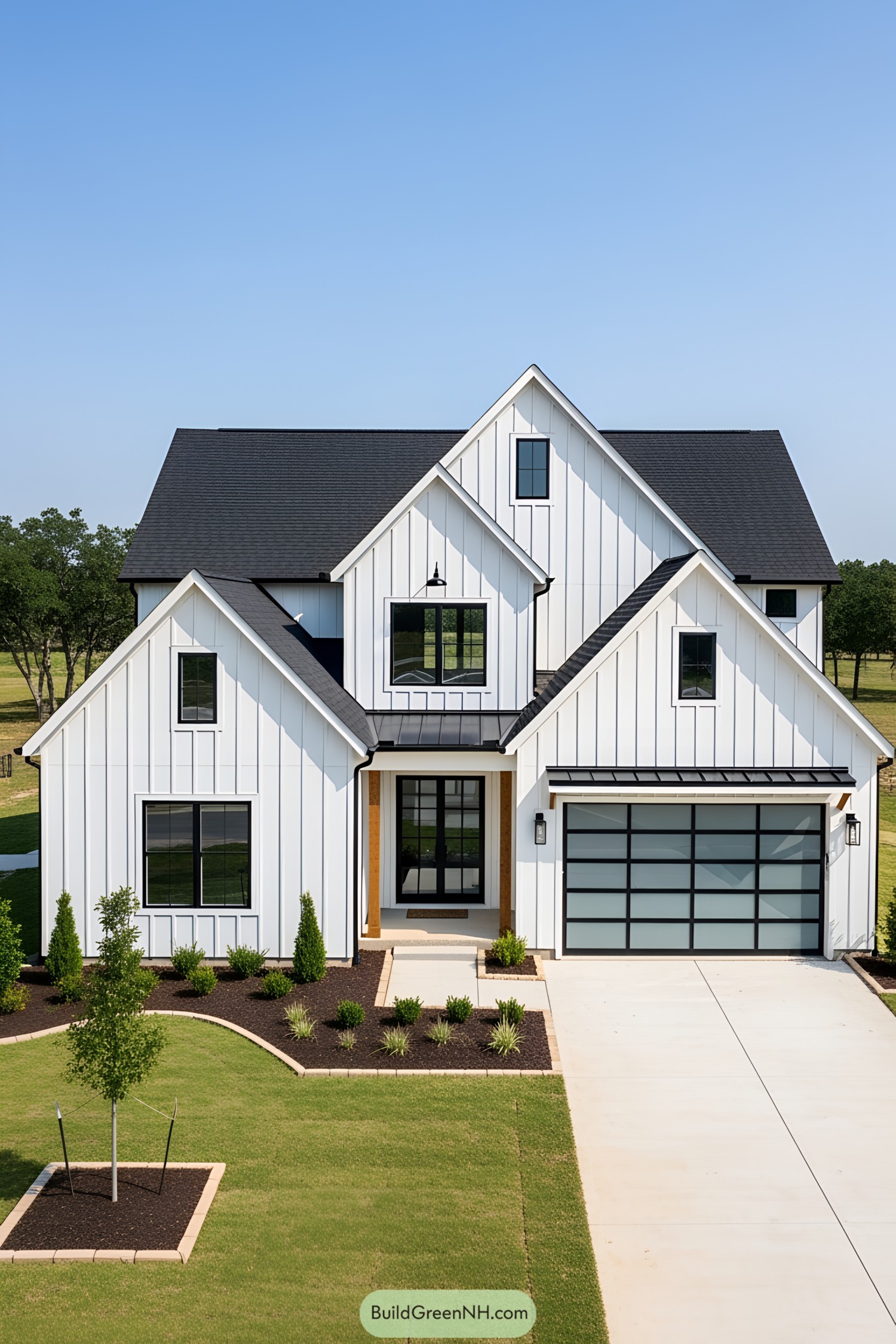 Modern white farmhouse with black roof and manicured lawn