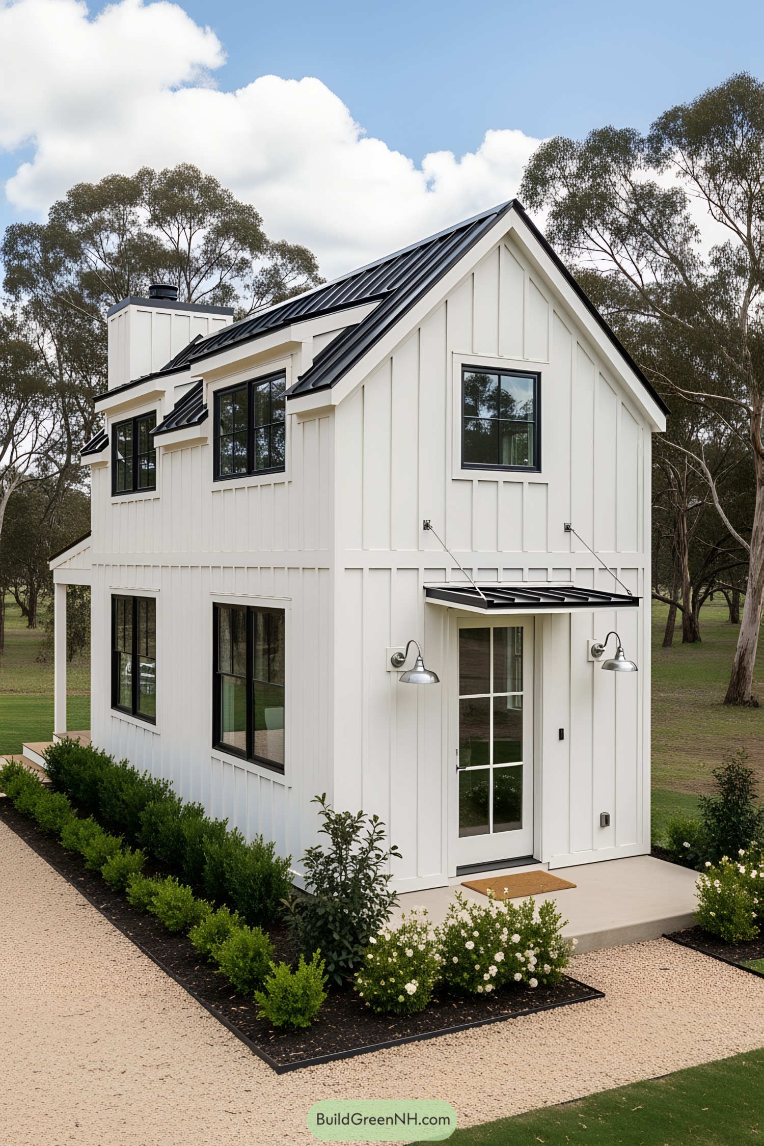 White tiny farmhouse with black roof and lush greenery