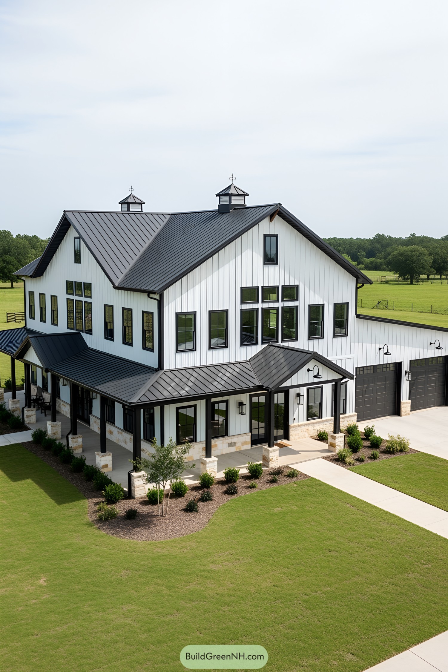 Large barndominium with black roof and white siding
